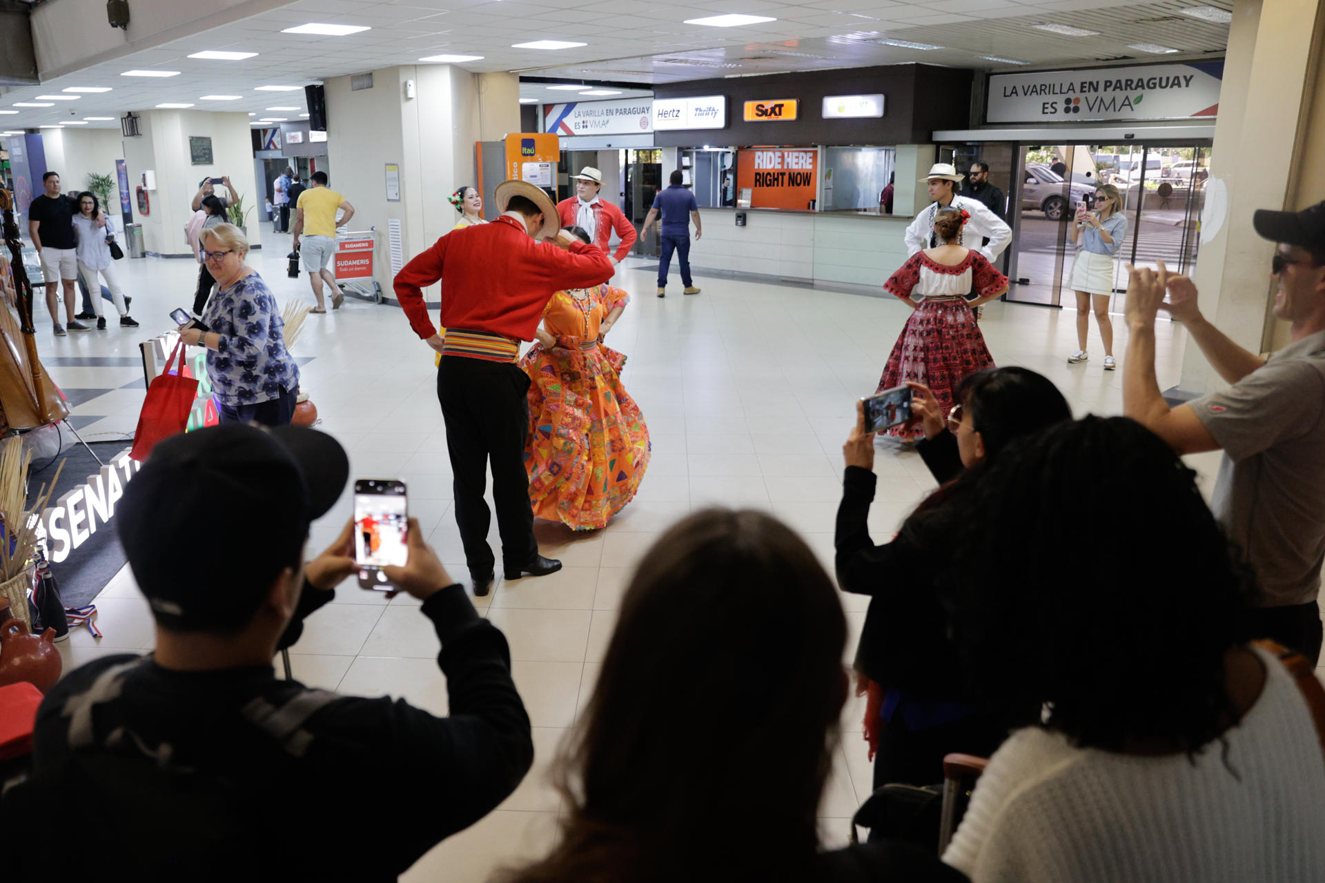 Asistentes al 75° Congreso Ordinario de la FIFA son recibidos con bailes típicos de Paraguay, en el Aeropuerto Internacional Silvio Petirossi, en Luque (Paraguay). EFE/Juan Pablo Pino
