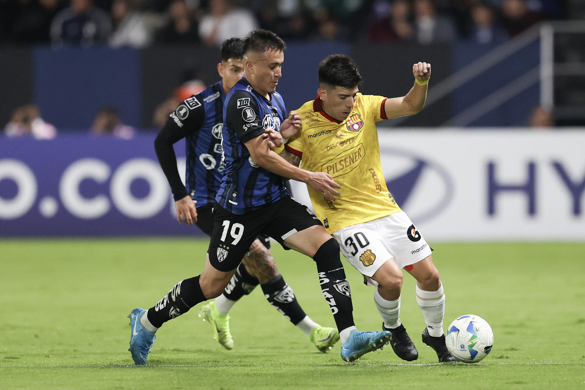 Layan Loor (c), de Independiente del Valle, disputa el balón con Brian Oyola, de Barcelona, en un partido de la fase de grupos de la Copa Libertadores entre Independiente del Valle y Barcelona, en el estadio Banco Guayaquil de Quito (Ecuador). EFE/ José Jácome
