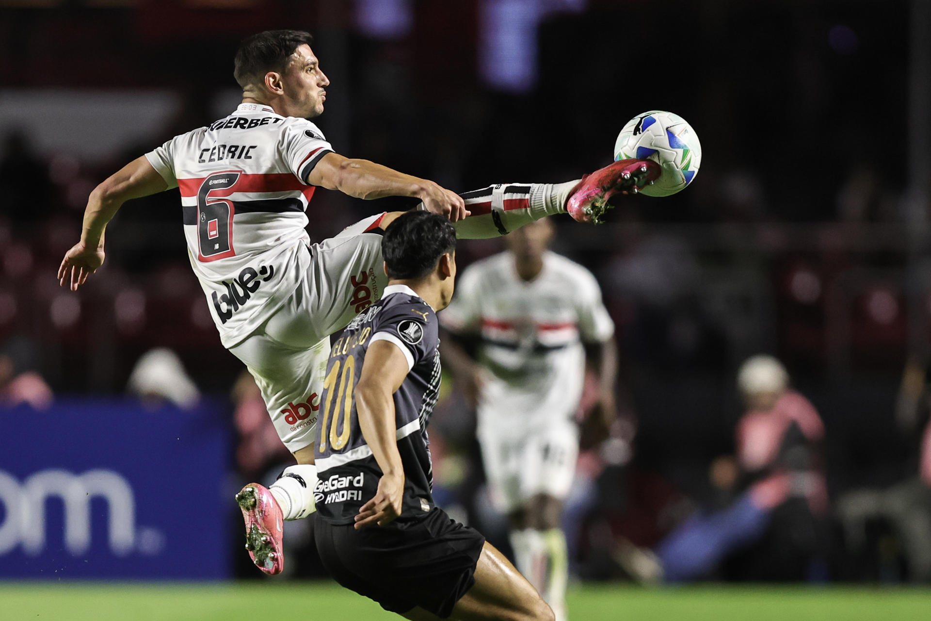 Cédric (arriba) de Sao Paulo disputa un balón con Lorenzo Melgarejo de Libertad en el partido de la quinta fecha de la fase de grupos de la Copa Libertadores que igualaron este miércoles 1-1 en el estadio Morumbi. EFE/ Isaac Fontana
