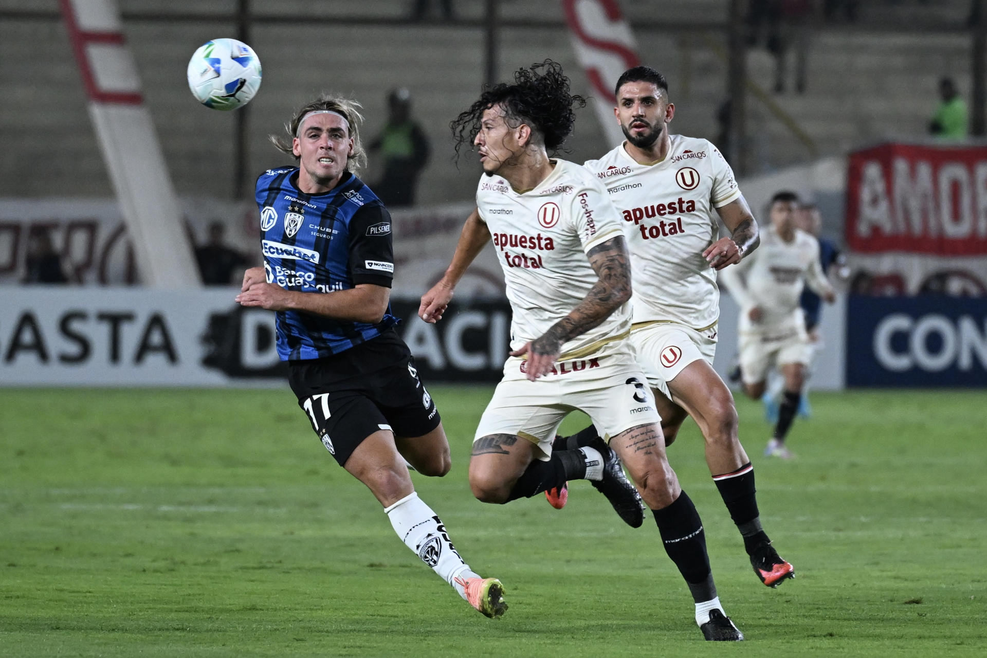 Williams Riveros (c), de Universitario, disputa el balón con Aron Rodríguez de Independiente del Valle. EFE/ Paloma Del Solar