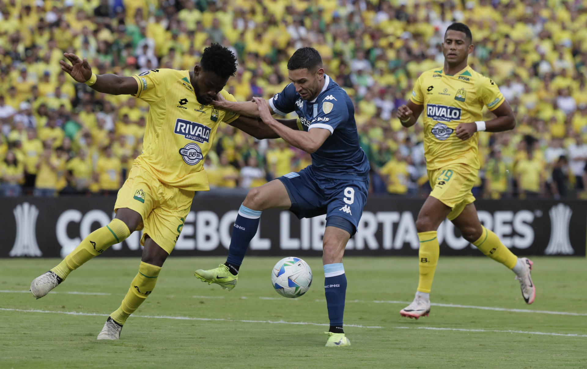 Carlos Romaña (i) de Bucaramanga disputa el balón con Adrián Emmanuel Martínez (c) de Racing en un partido de la fase de grupos de la Copa Libertadores. EFE/ Carlos Ortega