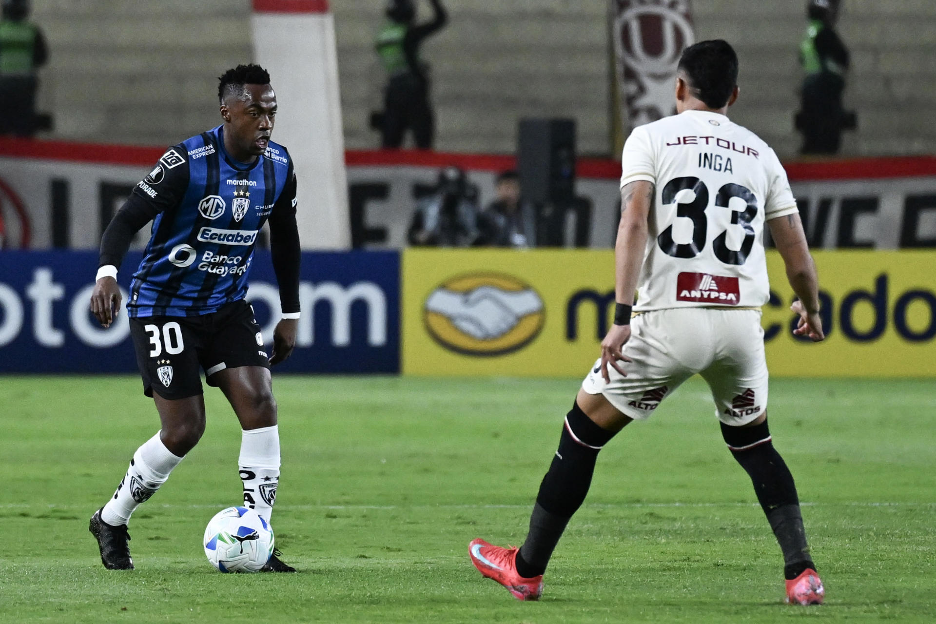 César Inga (d) de Universitario disputa el balón con Alex Ibarra de Independiente del Valle. EFE/ Paloma Del Solar