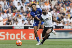 El defensa del Valencia Dimitri Foulquier (d) disputa el balón ante el delantero del Getafe Álvaro Rodríguez durante un partido de LaLiga EA Sports disputado en el Estadio de Mestalla en Valencia. EFE/Ana Escobar