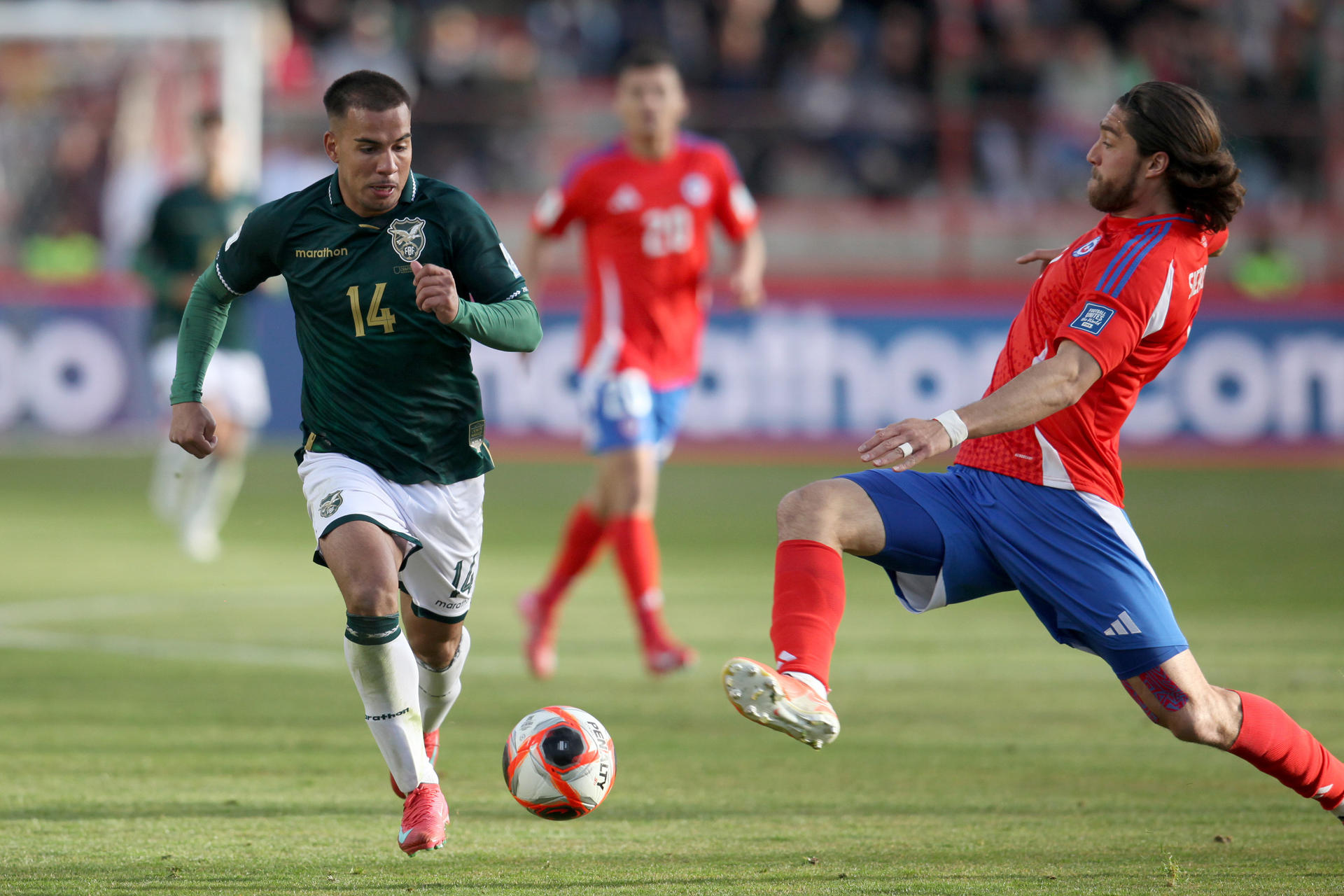 Robson Matheus (i) de Bolivia disputa el balón con Francisco Sierralta de Chile. EFE/Esteban Biba