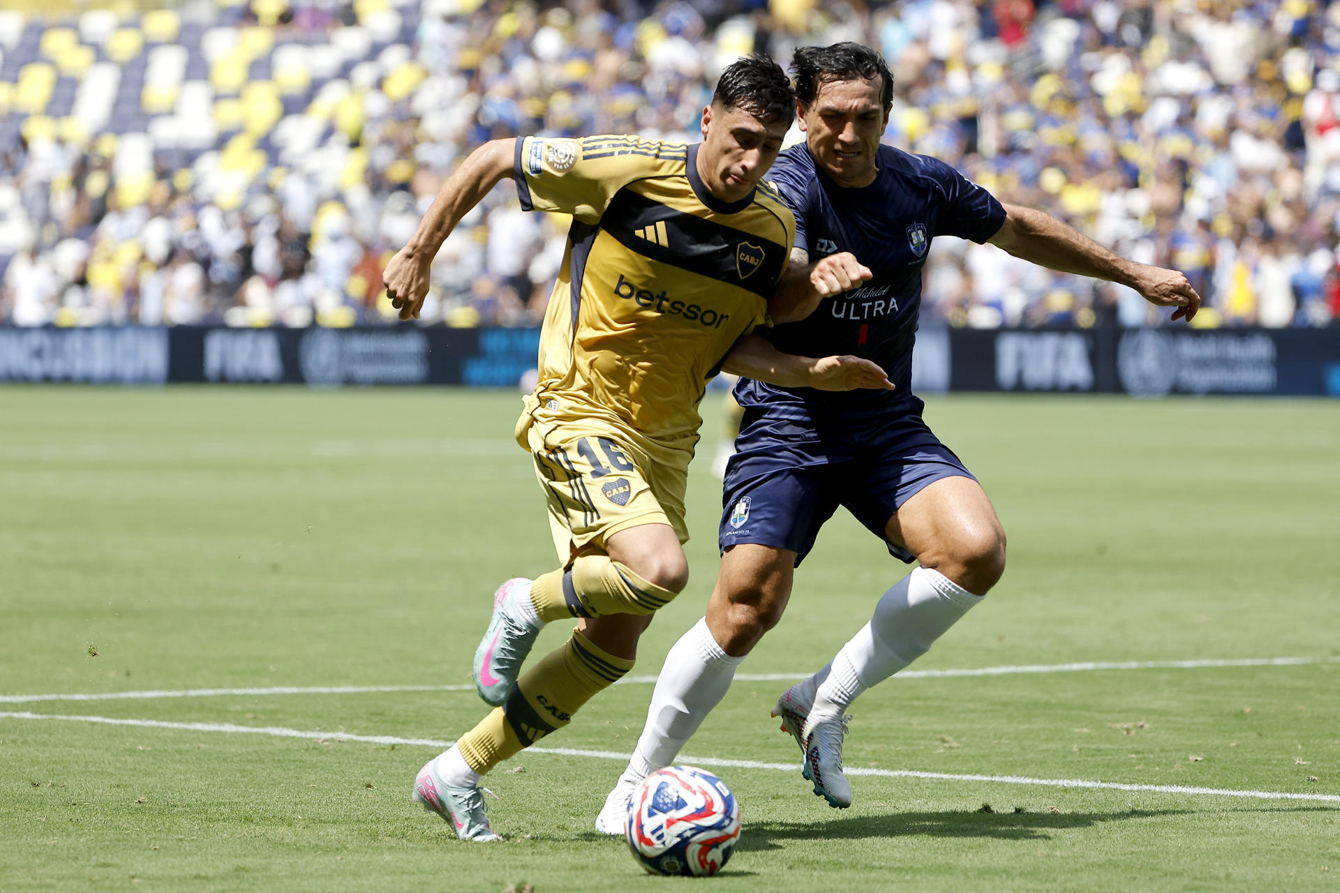 Miguel Merentiel, de Boca Juniors, avanza ante la marca de Nikko Boxall (d), de Auckland. EFE/Juan Ignacio Roncoroni
