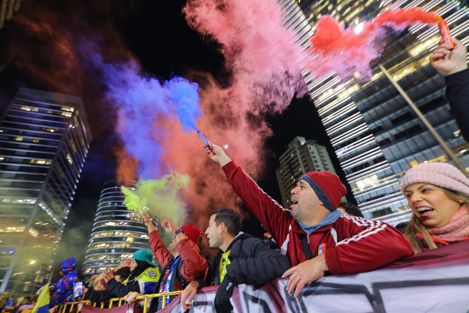 Hinchas sostienen bengalas durante el recibimiento a la selección de Venezuela en Uruguay. EFE/ Gastón Britos
