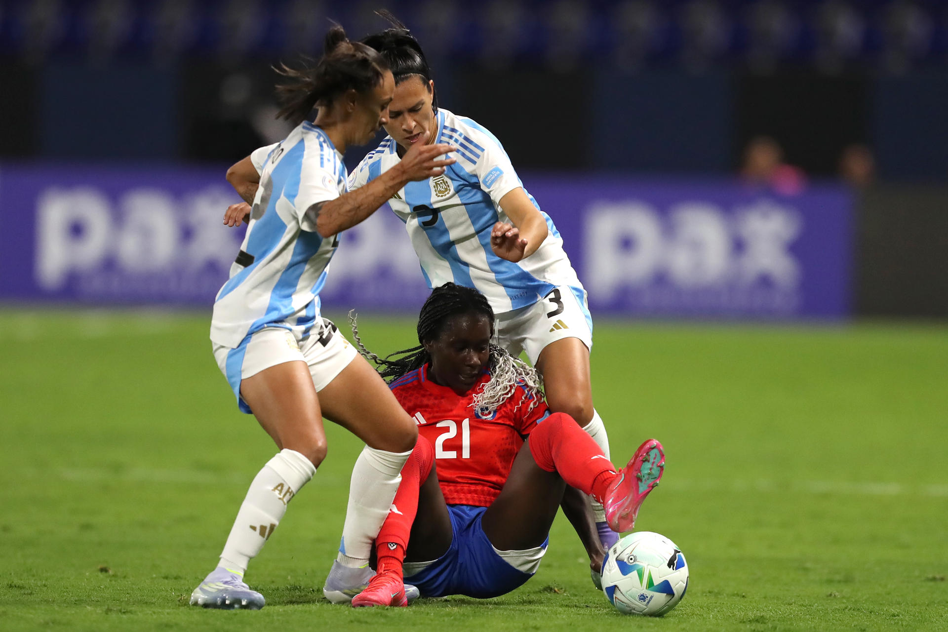Las argentinas Eliana Stabile (d) y Betina Soriano de Argentina disputan el balón con la chilena Mary Valencia durante el partido de la Copa América que la selección Albiceleste ganó este viernes de remontada por 2-1 en el estadio Banco Guayaquil de Quito. EFE/ Jóse Jácome 