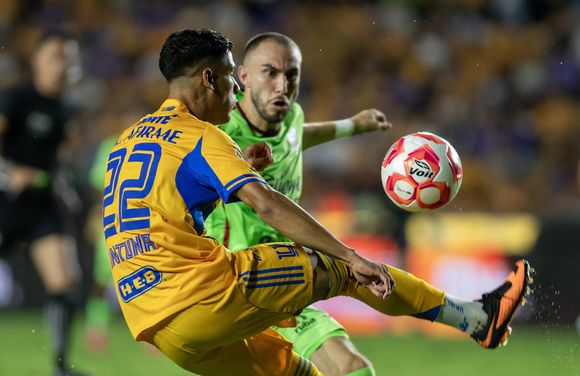 Ariel Antuna (i) domina el balón ante la marca del defensor de Juárez Manuel Mayorga durante el partido de la segunda jornada del Torneo Apertura mexicano que Tigres ganó por 1-0 en el estadio Universitario de Monterrey. EFE/Miguel Sierra 