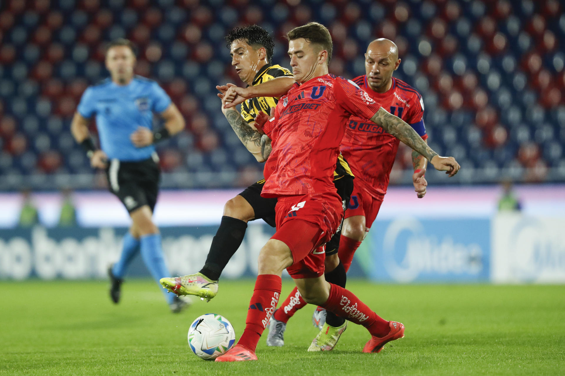 El defensor de Guaraní Agustín Manzur (atrás) disputa el balón con el extremo de Universidad de Chile Franco Calderón durante el partido de vuelta de la repesca por un cupo en los octavos de final de la Copa Sudamericana que clasificó a la formación chilena en el estadio asunceno La Nueva Olla. EFE/ Juan Pablo Pino 