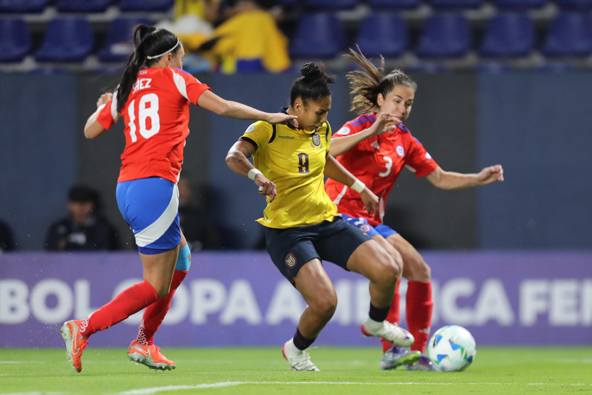 Camila Sáez (i) y Fernanda Mellado (d), de Chile, disputan el balón con Nayely Bolaños, de Ecuador, en un partido de la fase de grupos de la Copa América Femenina entre Chile y Ecuador en el estadio Banco de Guayaquil en Quito (Ecuador). EFE/ José Jácome 