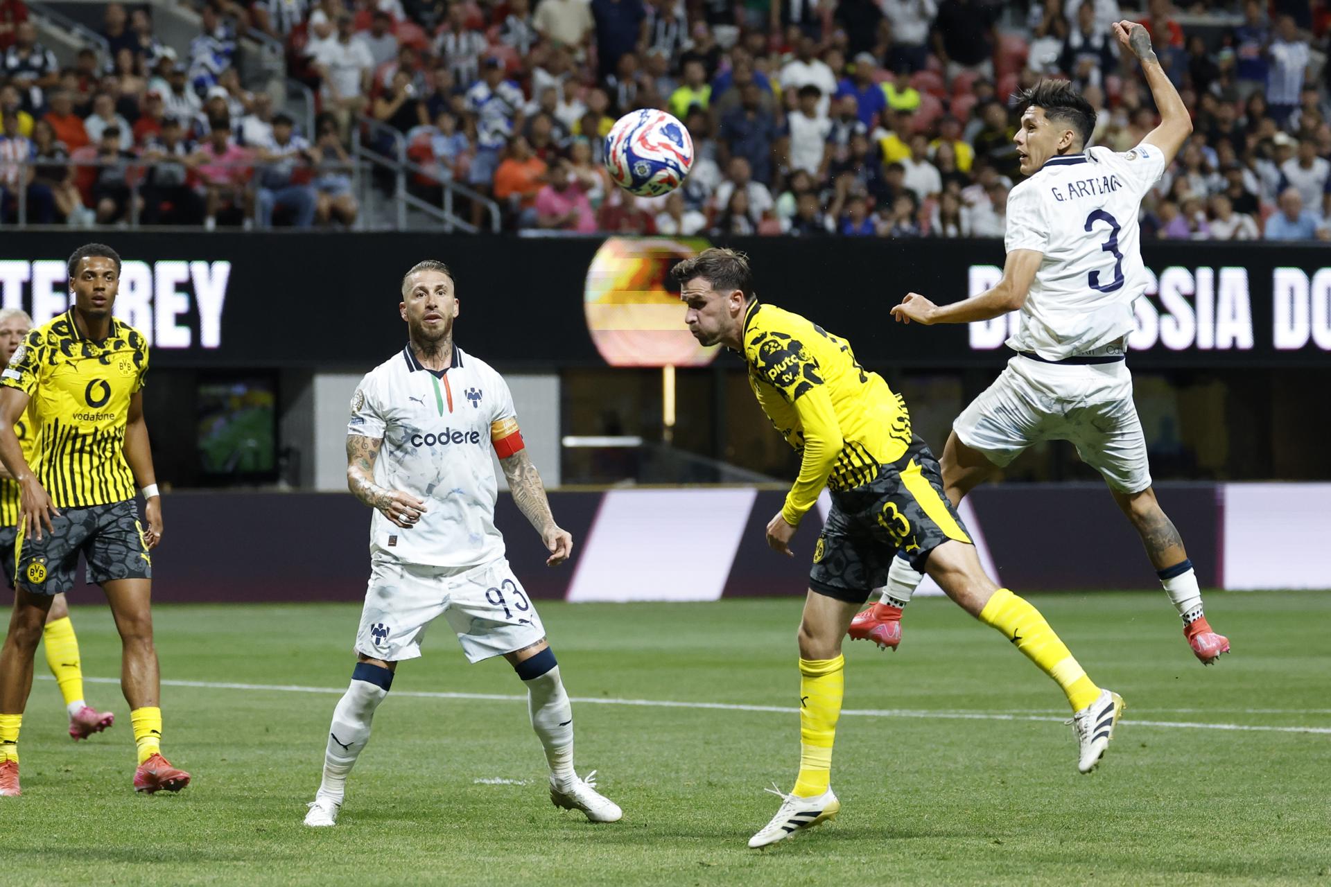 Pascal Gross, del Borussia Dortmund (c), cabecea ante la marca de Gerardo Arteaga (d) y Sergio Ramos, del Monterrey (2-i). EFE/EPA/ERIK S. LESSER 