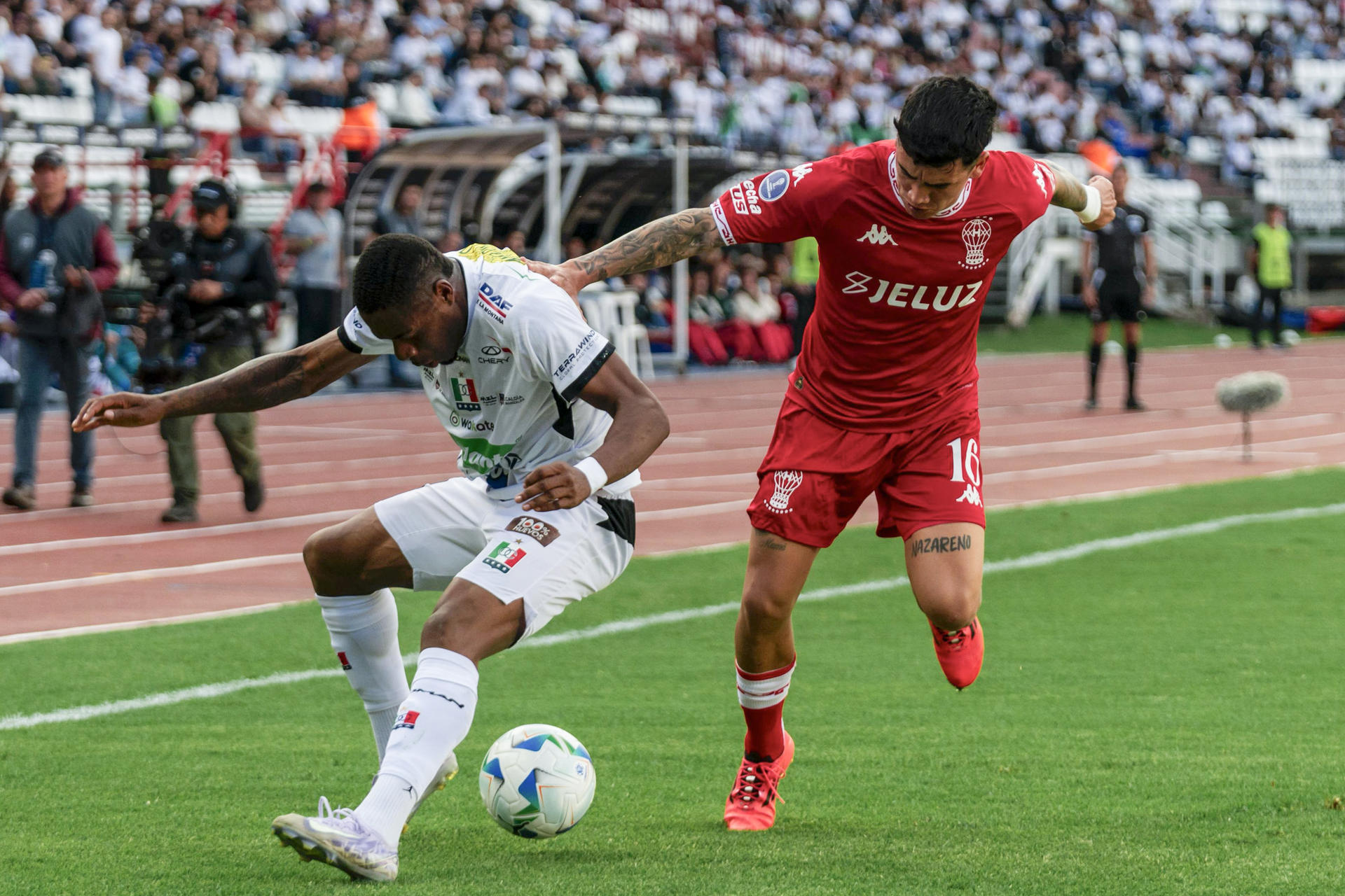 Luis Palacios (i) de Once Caldas disputa el balón con Rodrigo Cabral de Huracán este martes, durante un partido de octavos de final de la Copa Sudamericana. EFE/ Agencia Unido360 