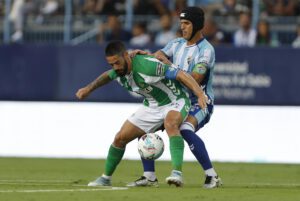 El centrocampista del Betis Isco Alarcón (i) lucha con Luismi, del Málaga, durante el partido del Torneo Costa del Sol, en el estadio de La Rosaleda. EFE/Jorge Zapata