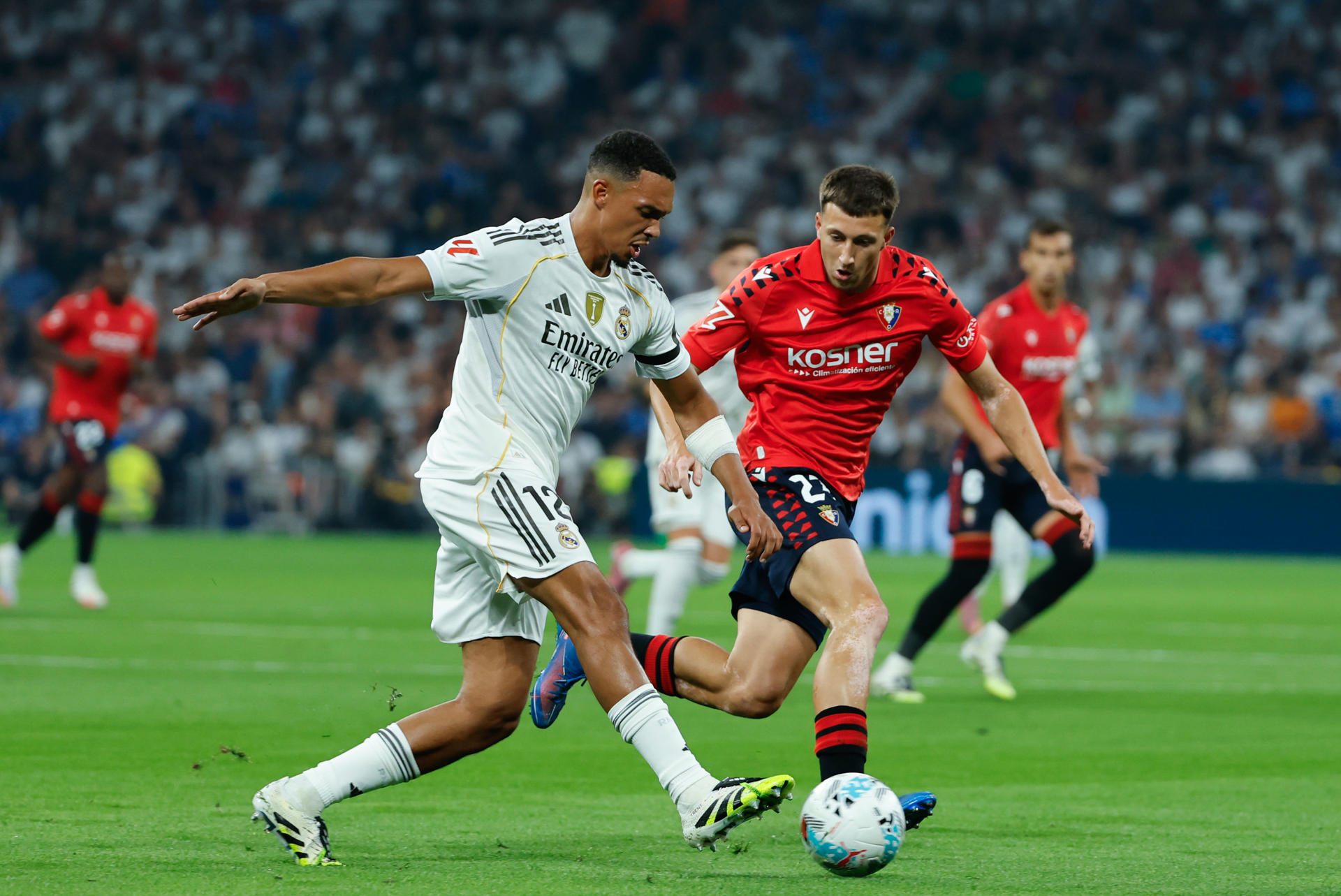 El defensa británico del Real Madrid Trent Alexander-Arnold (i) controla el balón junto a Abel Bretones, de Osasuna, durante el partido de la primera jornada de LaLiga que Real Madrid y Atlético Osasuna disputan en el estadio Santiago Bernabéu. EFE/Mariscal
