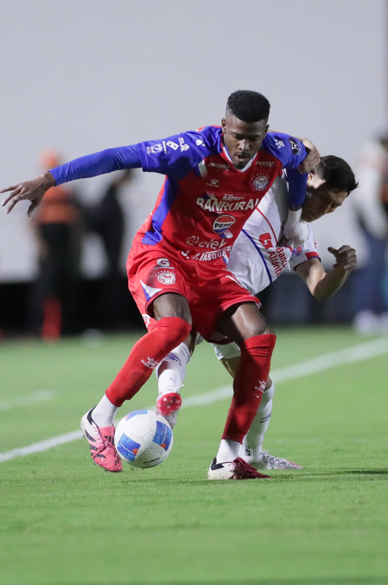 Derrickson Quirós (i) de Xelajú disputa el balón con Axel Maldonado de Olimpia durante un partido que cerró la actividad en el Grupo D de la Copa Centroamericana en el Estadio Nacional de Tegucigalpa. EFE/ Gustavo Amador 