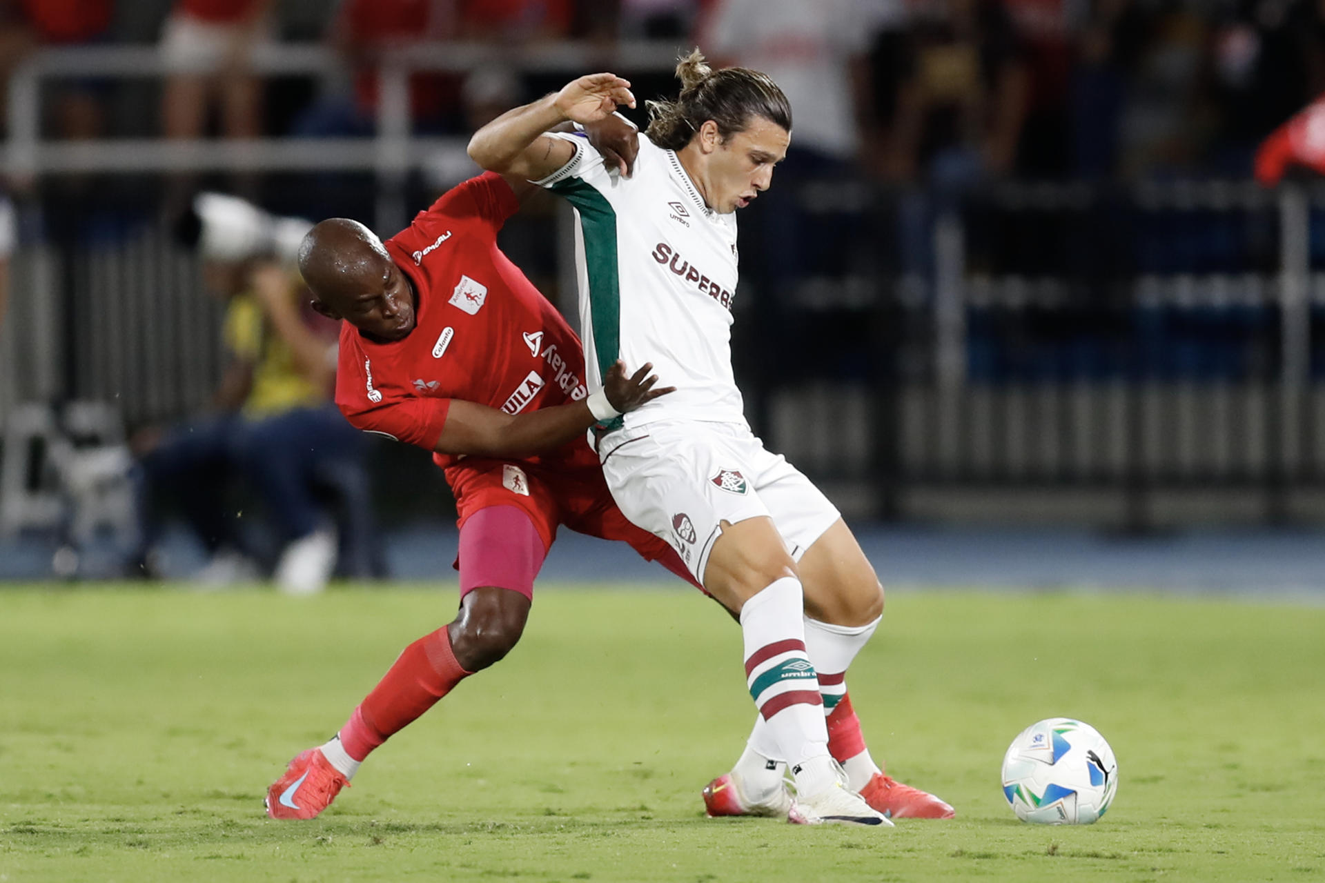 AMDEP118. CALI (COLOMBIA), 12/08/2025.- Marcos Mina (i) de América de Cali disputa el balón con Agustín Canobbion de Fluminense este martes, durante un partido de octavos de final de la Copa Sudamericana entre América de Cali y Fluminense en el estadio Pascual Guerrero de Cali (Colombia). EFE/ Ernesto Guzmán 