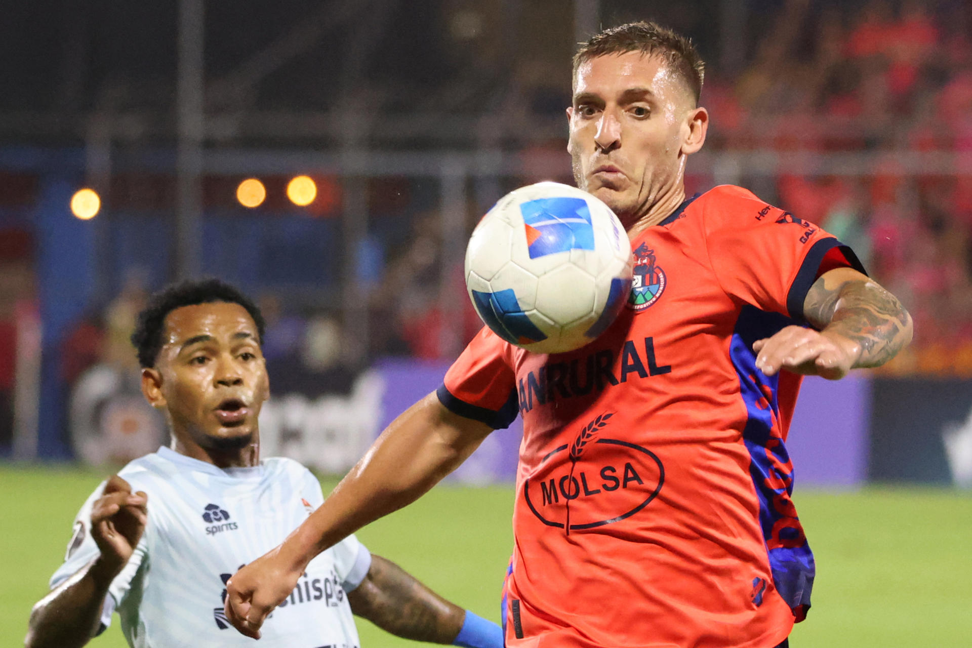 Cristian Hernández (d) de Municipal disputa el balón con Yair Jaén de San Miguelito este jueves, durante el partido de la Copa Centroamericana de la Concacaf que empataron 1-1 en el Estadio del Trébol en Ciudad de Guatemala. EFE / Fernando Ruiz 