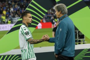 El delantero brasileño del Betis, Antony y el técnico chileno, Manuel Pellegrini, se saludan tras recibir la medalla de subcampeones de la Liga Europa. EFE / Julio Muñoz.