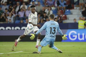 El delantero brasileño del Real Madrid Vinicius Jr. (i) intenta superar a Mathew Ryan, guardameta del Levante, durante el partido de la sexta jornada de LaLiga EA Sports que Levante UD y Real Madrid disputaron en el estadio Ciutat de Valencia. EFE/Ana Escobar
