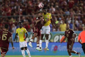 Josef Martínez (i), de Venezuela, disputa un balón con Jefferson Lerma, de Colombia, en partido por las eliminatorias al Mundial 2026. EFE/Ronald Peña R