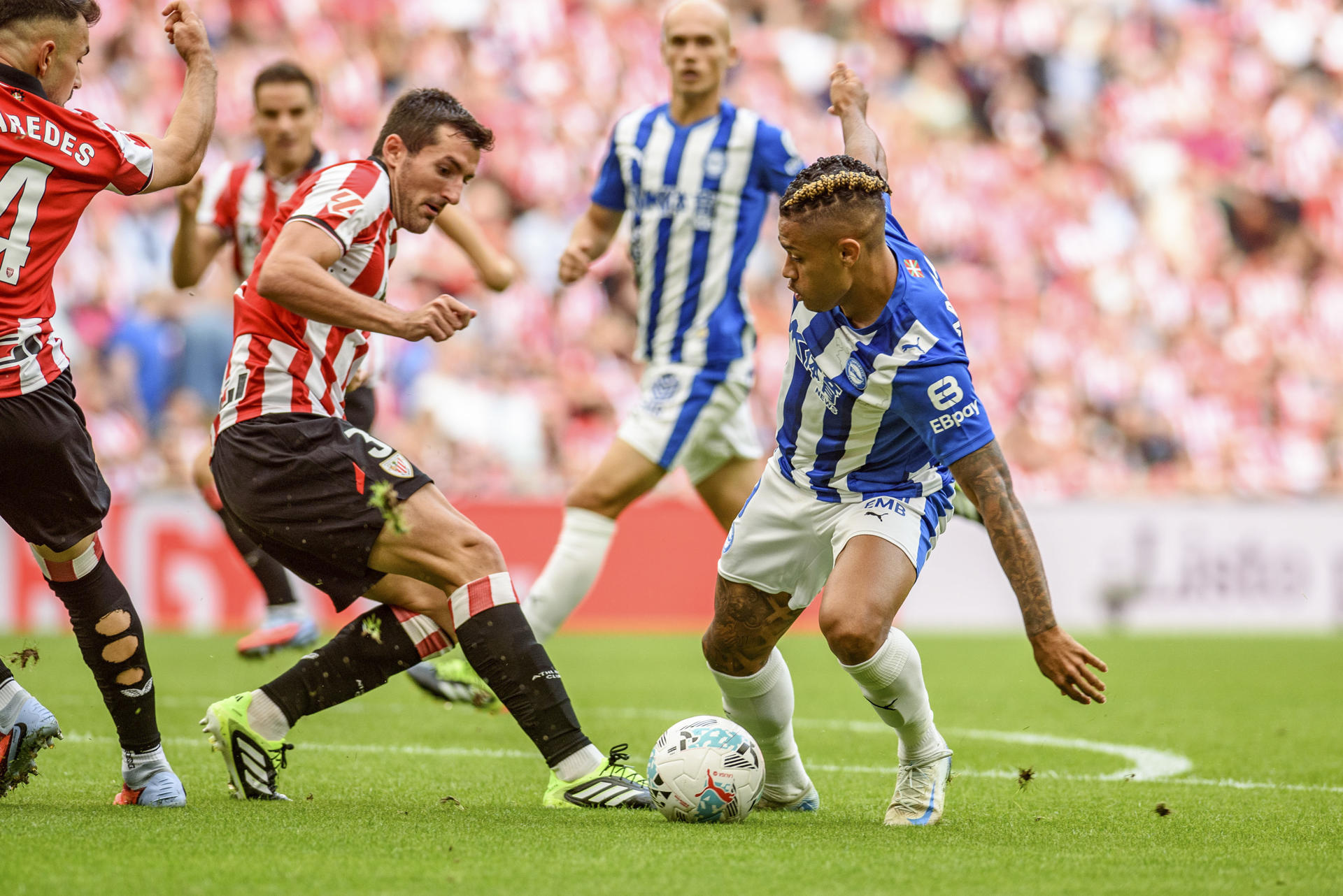 El delantero del Alavés Mariano Díaz (d) pelea un balón con el defensa del Athletic Club Dani Vivian (i), durante el partido de la jornada 4 de LaLiga EA Sports, este sábado en el estadio de San Mamés en Bilbao. EFE/Javier Zorrilla 
