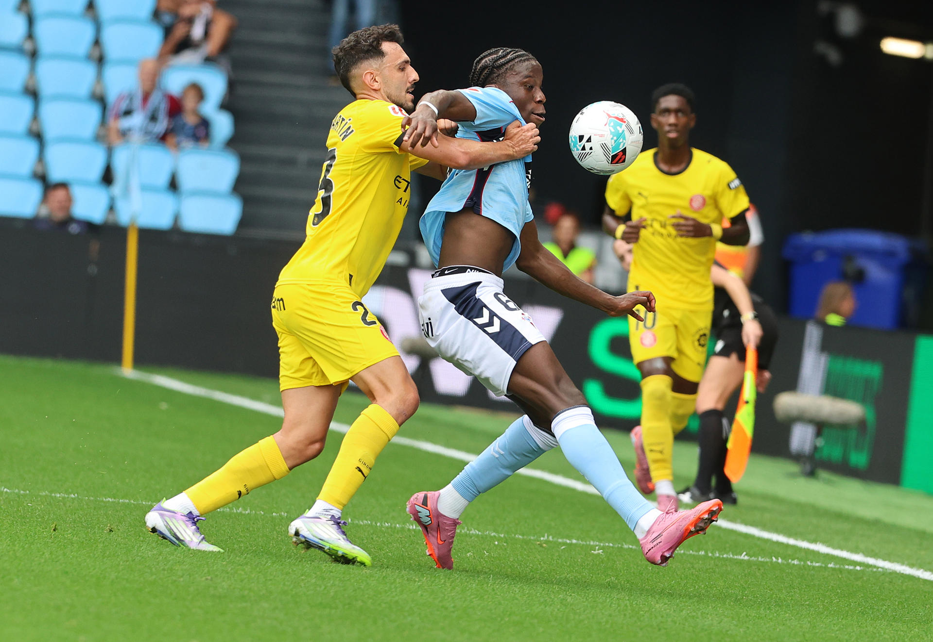 El jugador del Girona Hugo Rincón (i) lucha un balón con Moriba, del Celta de Vigo, durante el partido de la cuarta jornada de LaLiga disputado este domingo en el estadio de Balaidos de Vigo. EFE/Salvador Sas