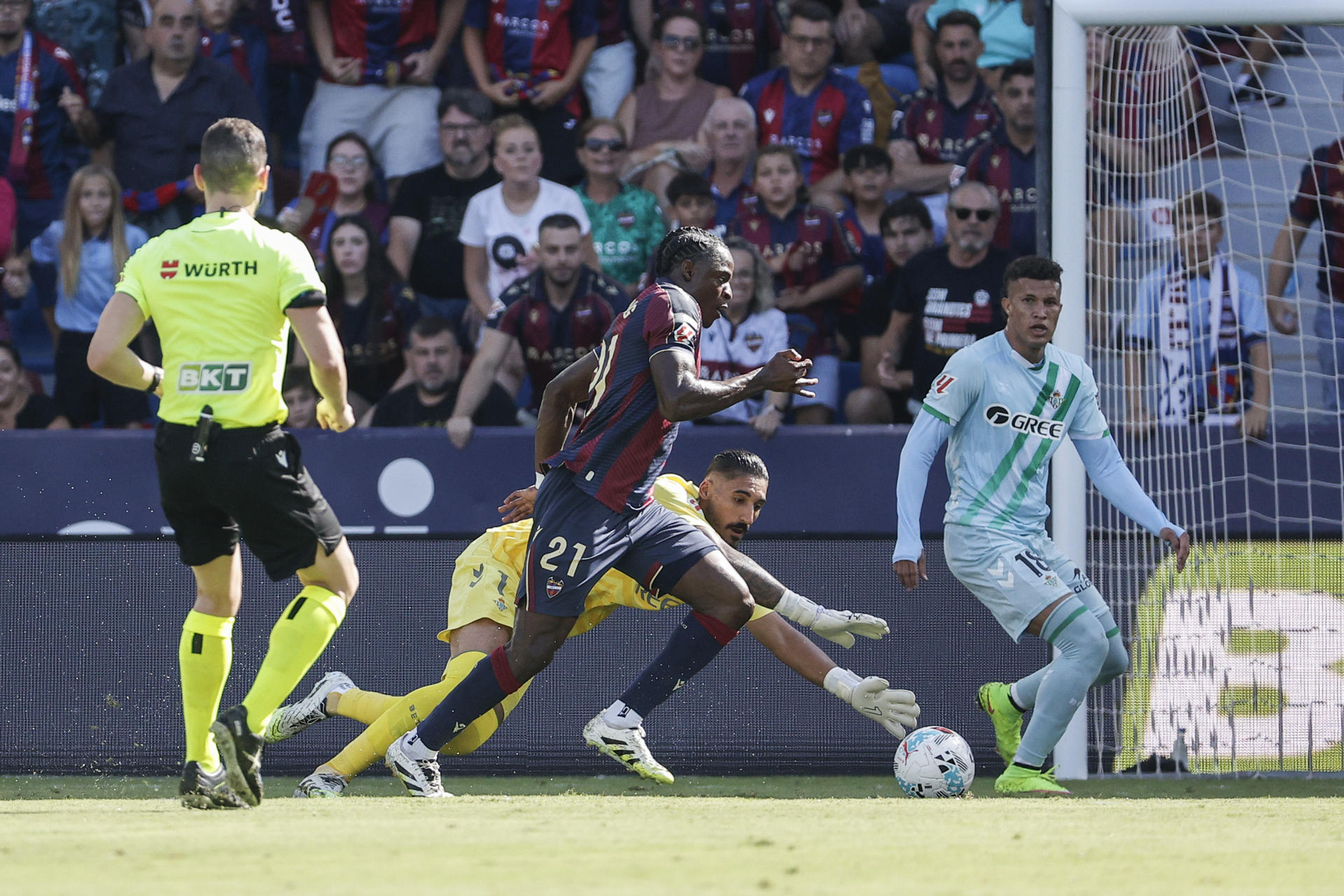 El delantero del Levante Karl Eyong supera para marcar gol al portero del Betis Álvaro Vallés, durante el partido de la jornada 4 de LaLiga EA Sports entre el Levante y el Betis, este domingo en el estadio gol Ciutat de València.- EFE/ Manuel Bruque 