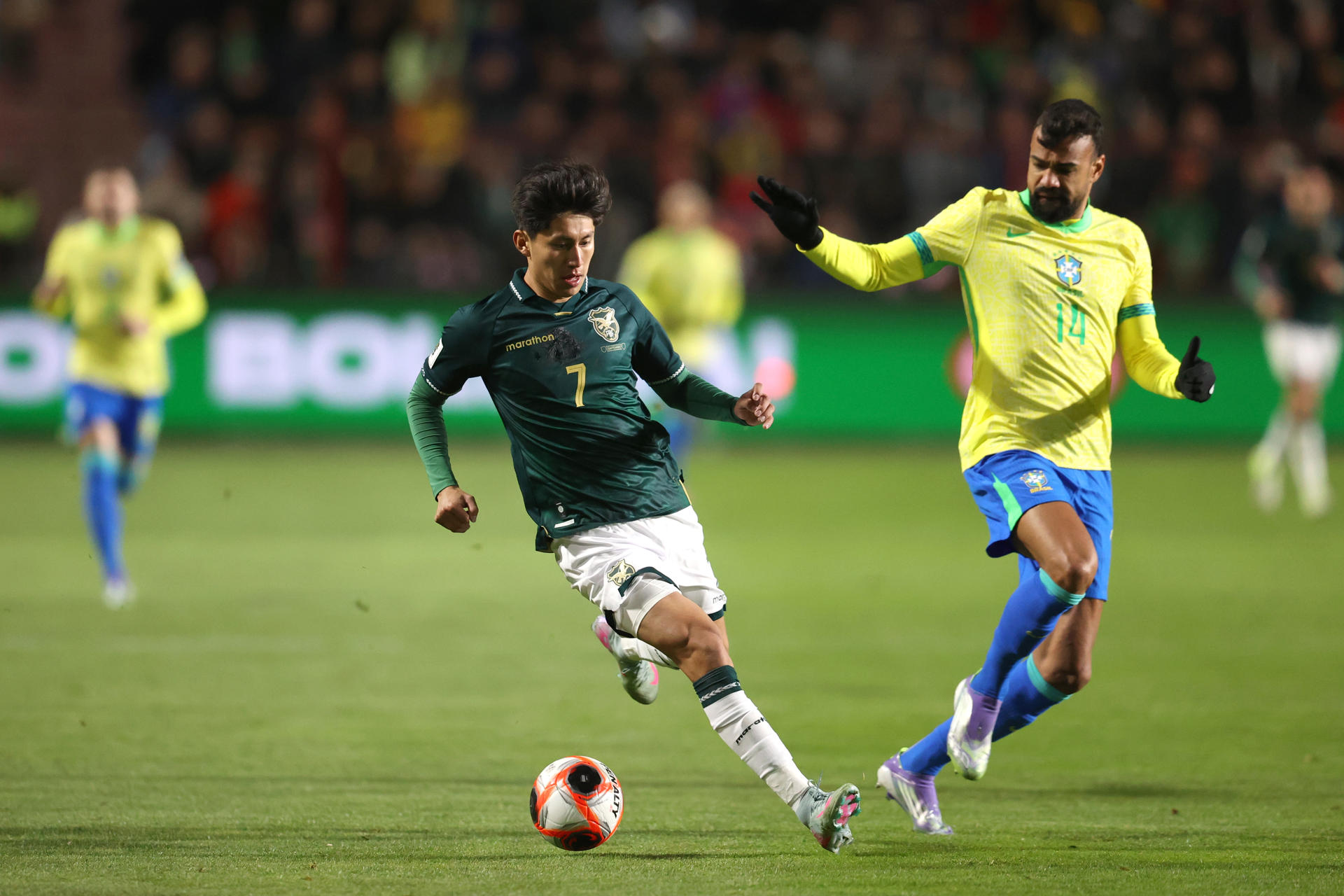 Miguel Terceros disputa el balón con Fabricio Bruno, de Brasil, en partido de las eliminatorias al Mundial 2026 en el Estadio Municipal de El Alto (Bolivia). EFE/Luis Gandarillas 