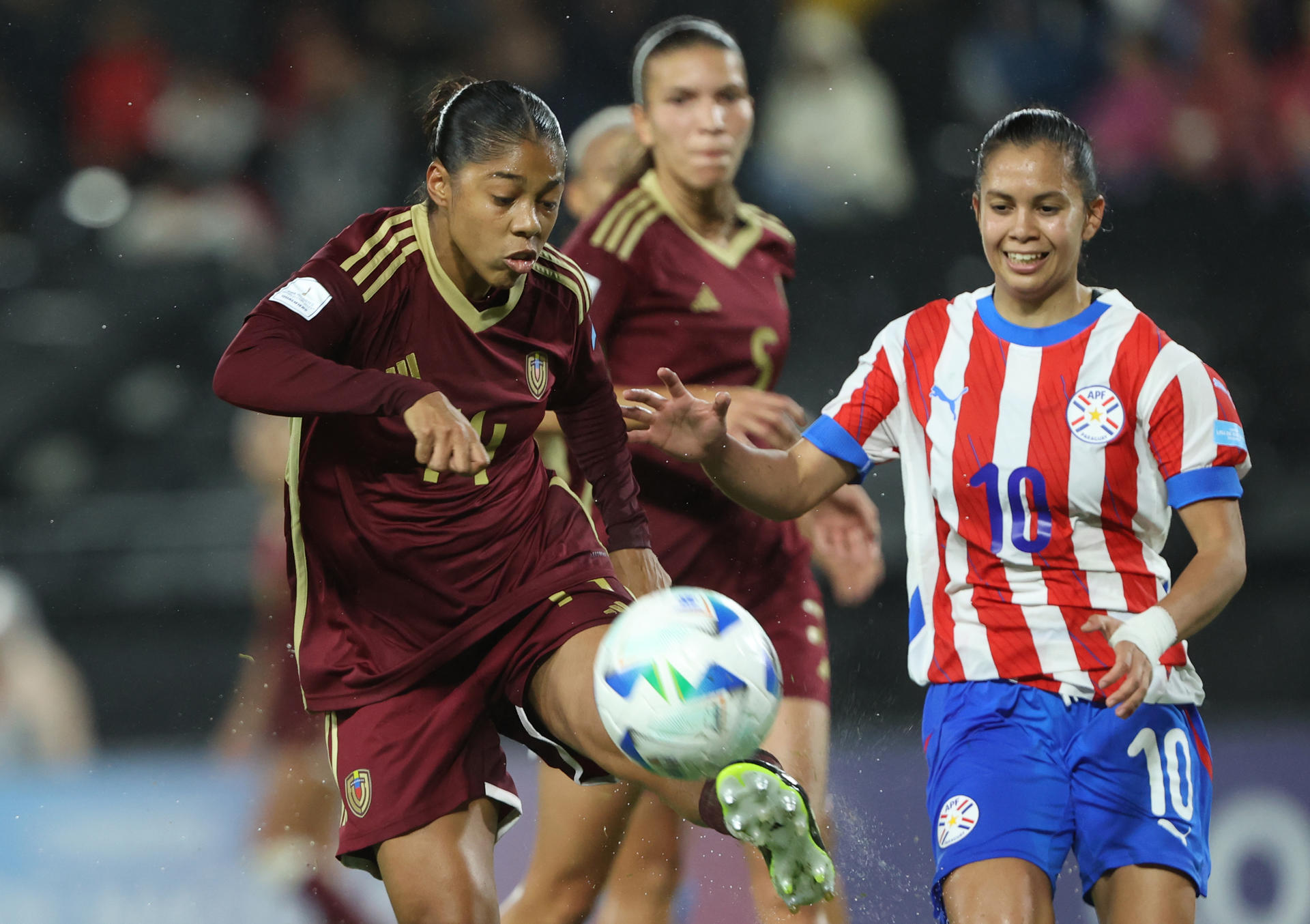 Fátima Acosta (d), de Paraguay, disputa un balón con Raiderlin Carrasco, de Venezuela, en un partido de la Liga de Naciones Femenina entre Paraguay y Venezuela en el estadio La Huerta, en Asunción (Paraguay). EFE/Juan Pablo Pino 