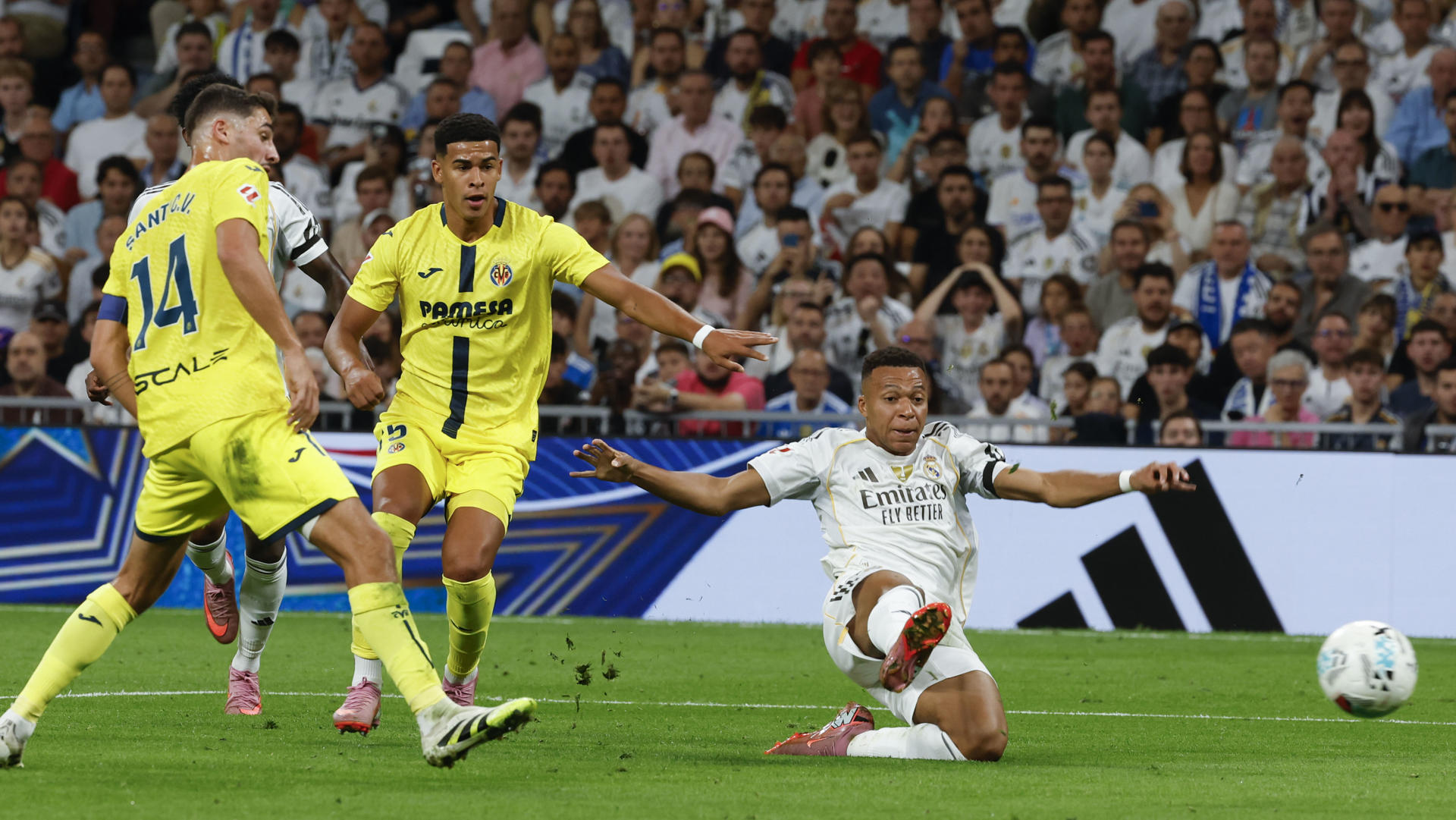 El delantero del Real Madrid Kylian Mbappé (d) juega un balón ante dos jugadores del Villarreal, durante el partido de LaLiga de fútbol que Real Madrid y Villarreal disputan en el estadio Santiago Bernabéu. EFE/Guillén 