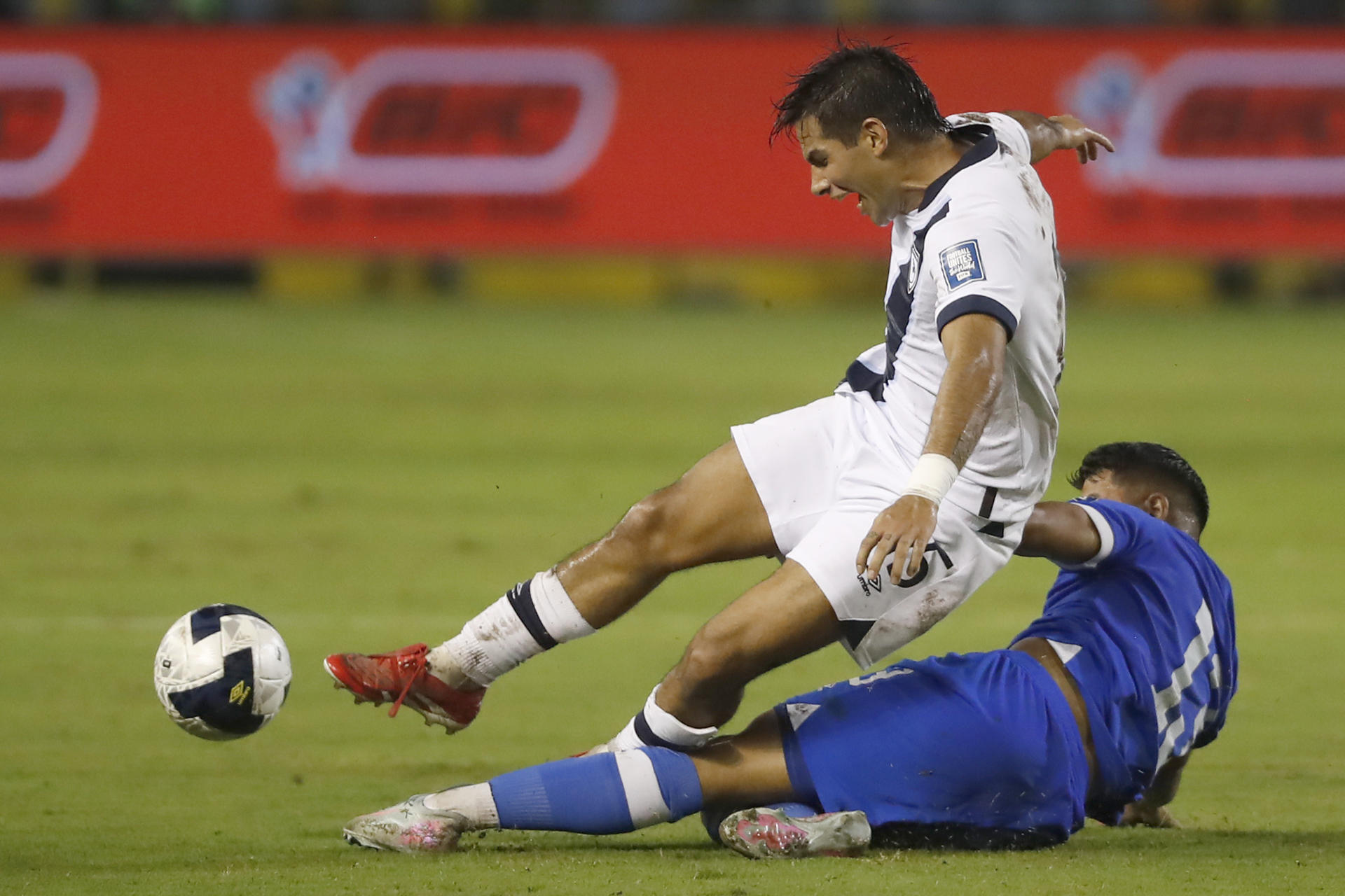 El defensor salvadoreño Adán Clímaco (abajo) cierra el avance del centrocampista guatemalteco Antonio de Jesús López durante el partido de la cuarta jornada del Grupo A de las eliminatorias de la Concacaf para el Mundial de 2026 jugado este martes en el estadio Cuscatlán de San Salvador. EFE/ Rodrigo Sura 