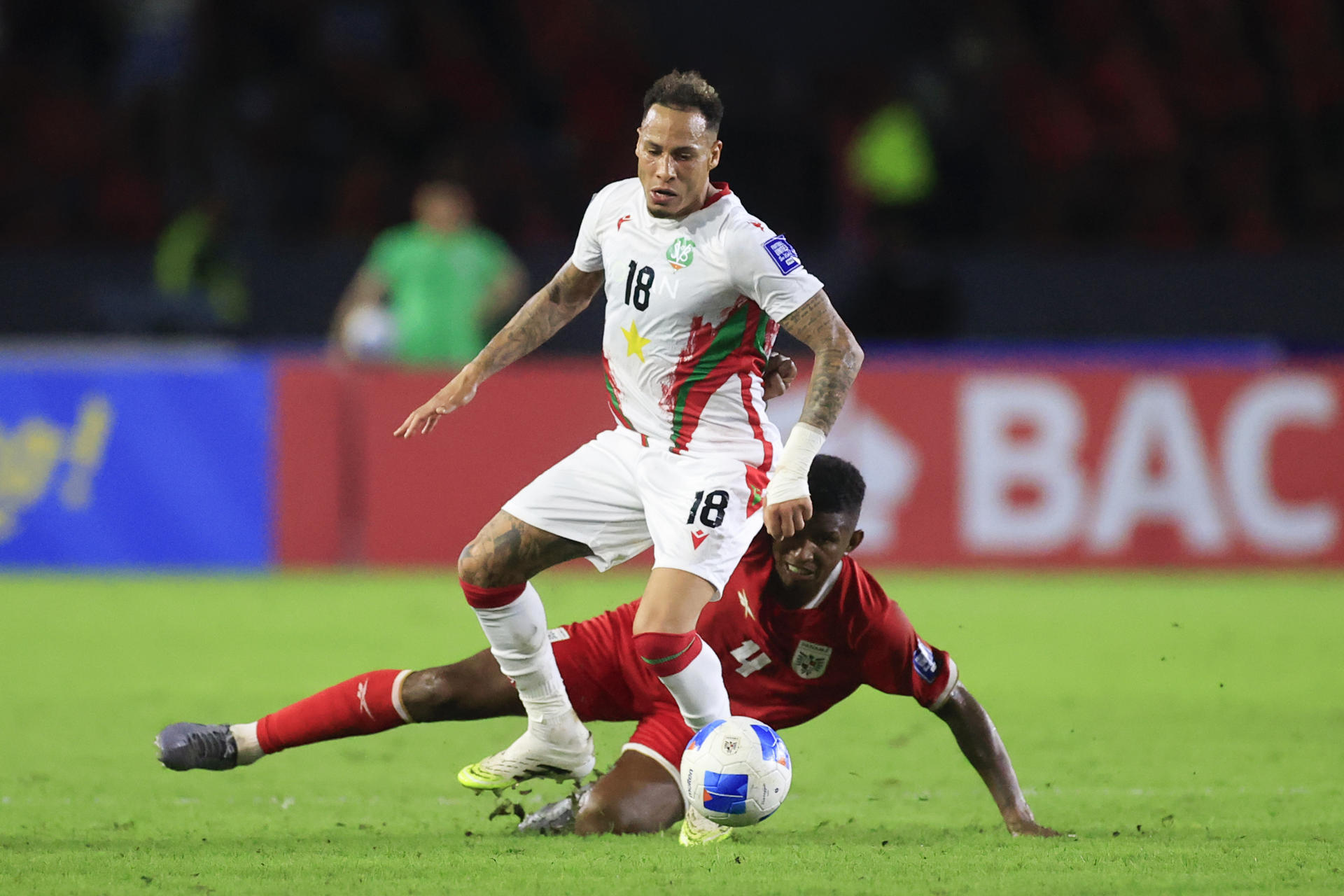 El defensor Fidel Escobar (abajo) es superado por el extremo surinamés Tjaronn Chery durante el partido de la cuarta jornada del Grupo A de las eliminatorias de la Concacaf para el Mundial de 2026 jugado este martes en el estadio Rommel Fernández Gutiérrez, de Ciudad de Panamá. EFE/ Bienvenido Velasco 