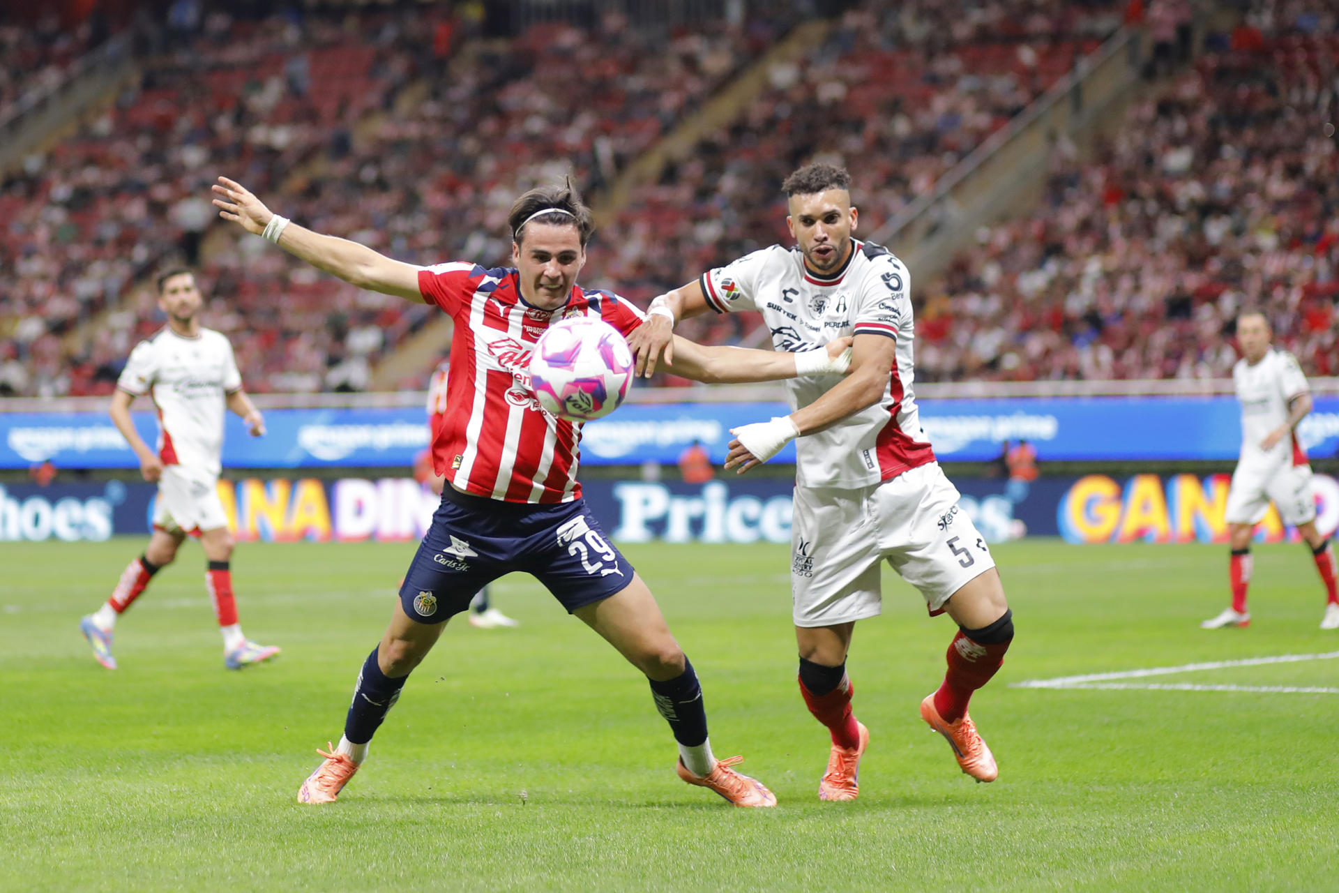 Teun Wilke (izq.) del Guadalajara disputa el balón con Matheus Doria, del Atlas, este sábado durante un partido de la Liga MX en el Estadio Akron (México). EFE/ Francisco Guasco 