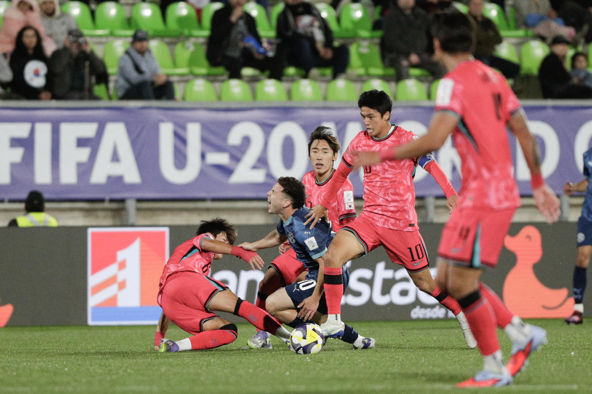 Son Seung-Min (i) y Kim Tae-won (d) de Corea del Sur disputan el balón con Enso González de Paraguay este martes en un partido de la Copa Mundial Sub-20 en el estadio Elías Figueroa, en Valparaíso (Chile). EFE/ Adriana Thomasa 