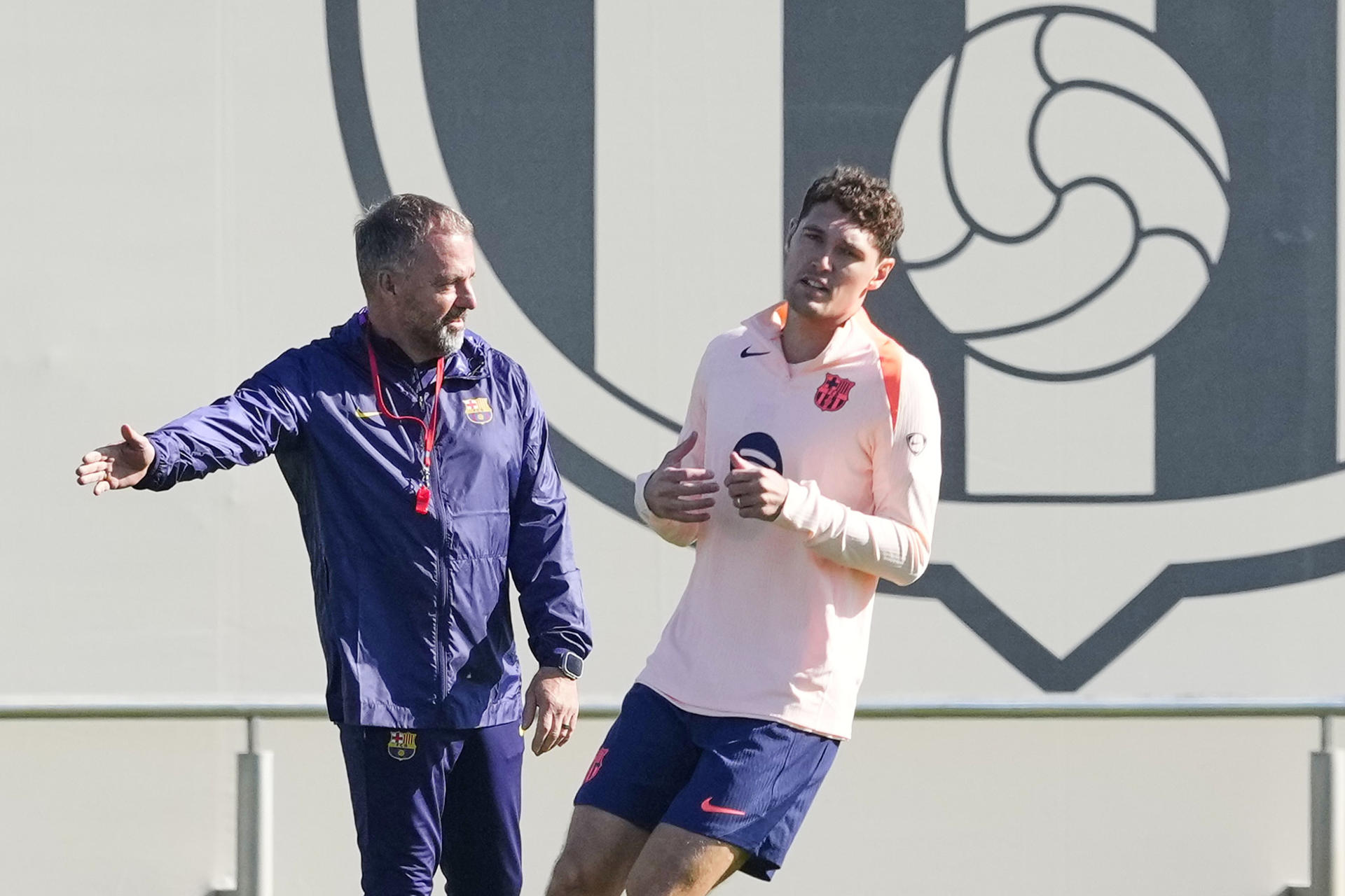 El entrenador del FC Barcelona, Hansi Flick, y el jugador Andreas Christensen durante el entrenamiento que el equipo azulgrana ha realizado en la ciudad deportiva Joan Gamper para preparar el aprtido de Liga de Campeones que disputarán ante el Brujas. EFE/Alejandro García 