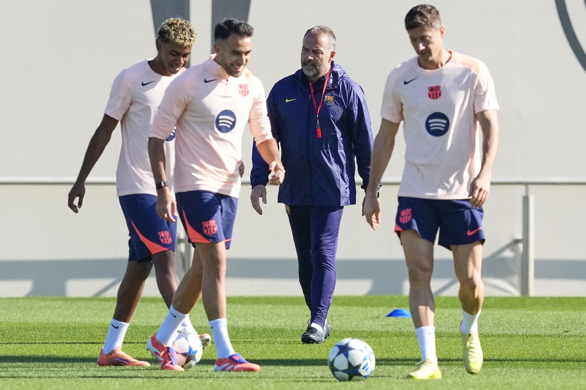 El entrenador del FC Barcelona, Hansi Flick, y los jugadores Lamine Yamal (i), Eric García (2i) y Robert Lewandowski (d) durante el entrenamiento que el equipo azulgrana ha realizado en la ciudad deportiva Joan Gamper para preparar el partido de Liga de Campeones que disputarán ante el Brujas. EFE/Alejandro García 