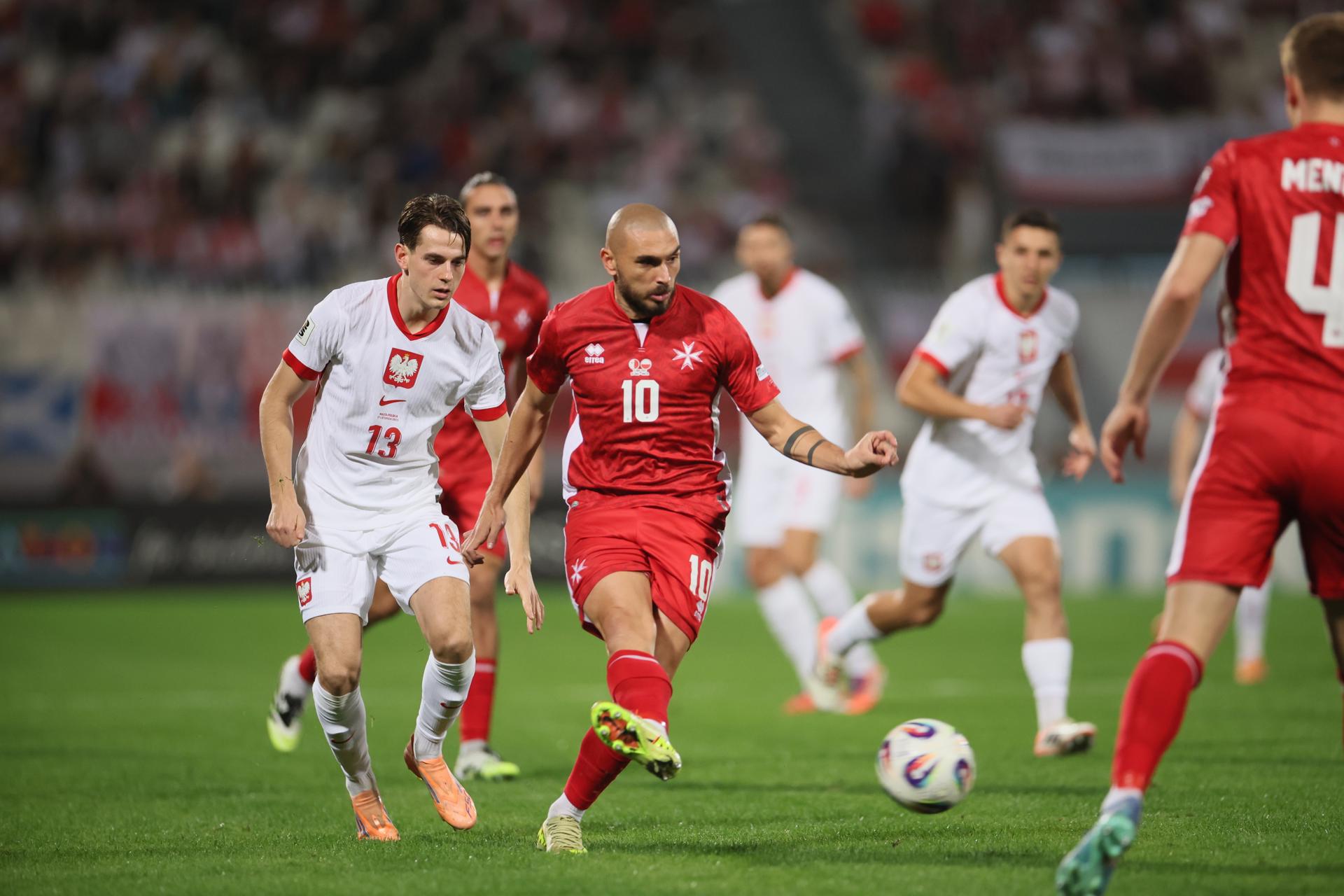El polaco Jakub Kaminski (i) y Teddy Teuma (c), de Malta, en acción durante el partido que ambas selecciones disputaron este lunes, correspondiente a la fase de clasificación europea para el Mundial 2026. EFE/ Leszek Szymanski *POLAND OUT* 