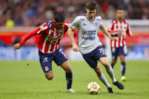 Bryan González (i) de Guadalajara disputa el balón con José Paradela de Cruz Azul este jueves, en un partido de cuartos final de la Liga MX entre Guadalajara y Cruz Azul en el Estadio Akron, en Guadalajara (México). EFE/ Francisco Guasco