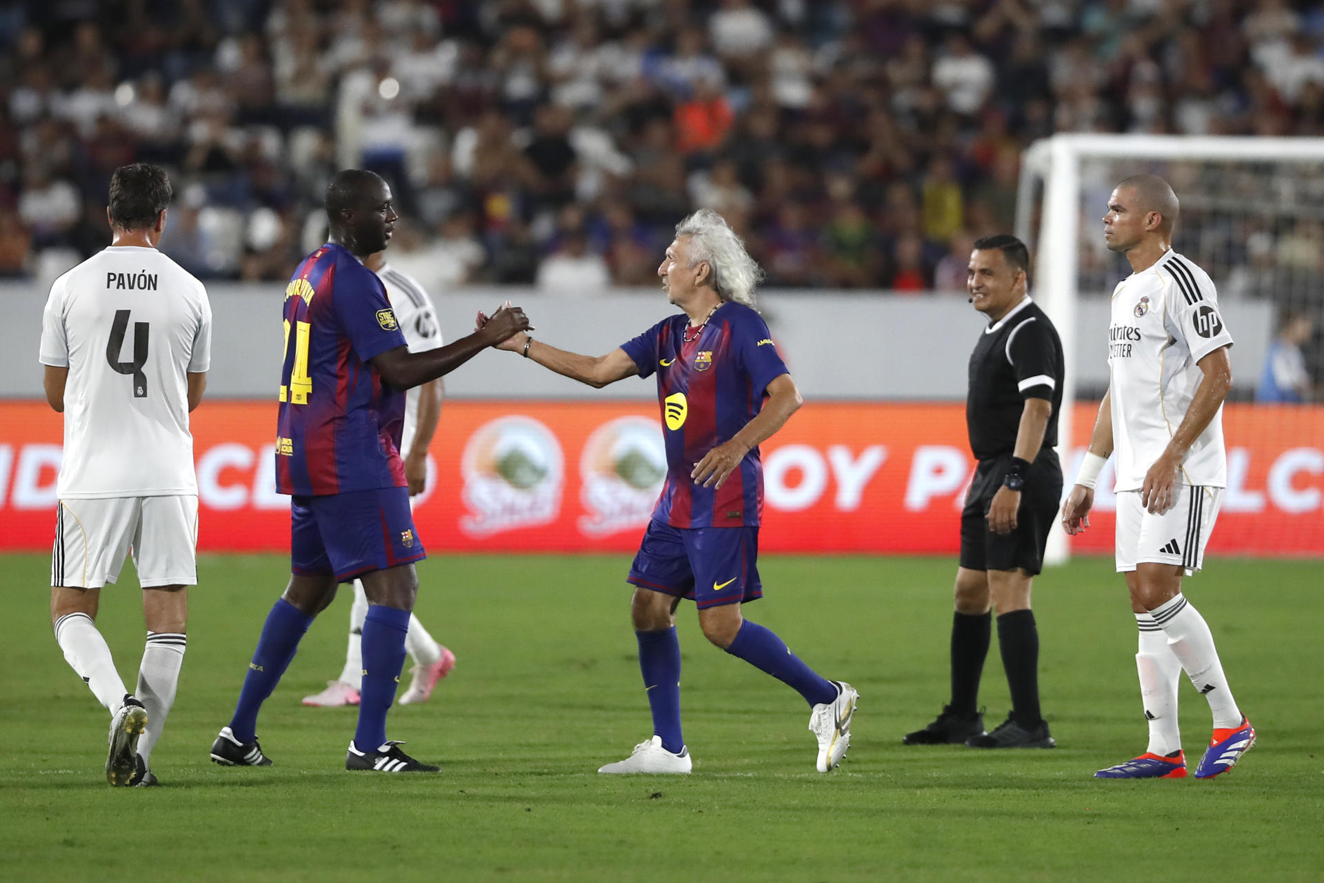 Los jugadores de FC Barcelona Leyendas Yaya Touré (2-i) y Jorge 'Mágico' González (c) se saludan durante un partido ante el Real Madrid Leyendas en San Salvador. EFE/Rodrigo Sura 