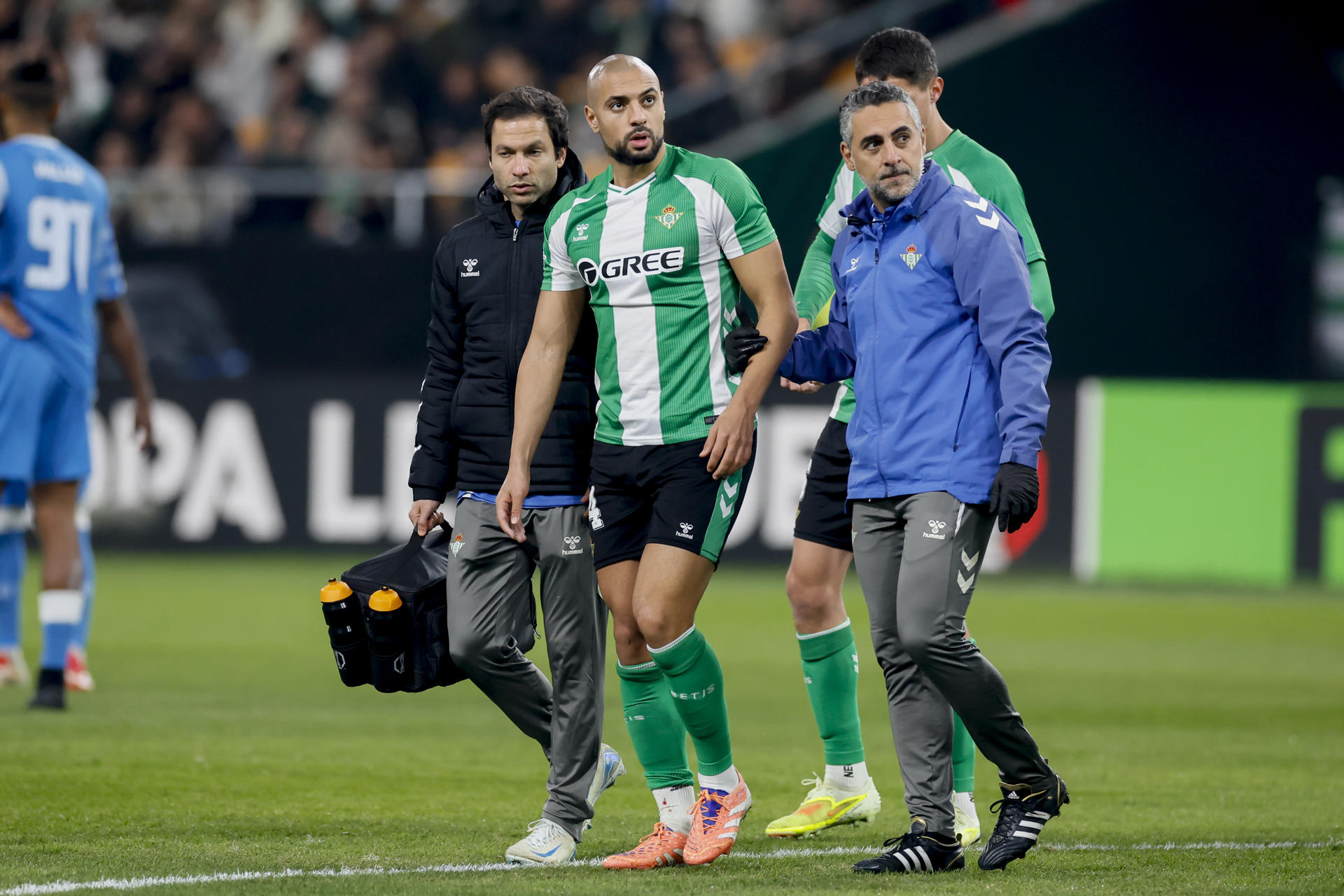 El jugador del Real Betis Sofyan Amrabat (2i) se retira lesionado durante el partido de Liga Europea UEFA disputado ante el FC Utrecht, este jueves en el estadio de La Cartuja. EFE/José Manuel Vidal 