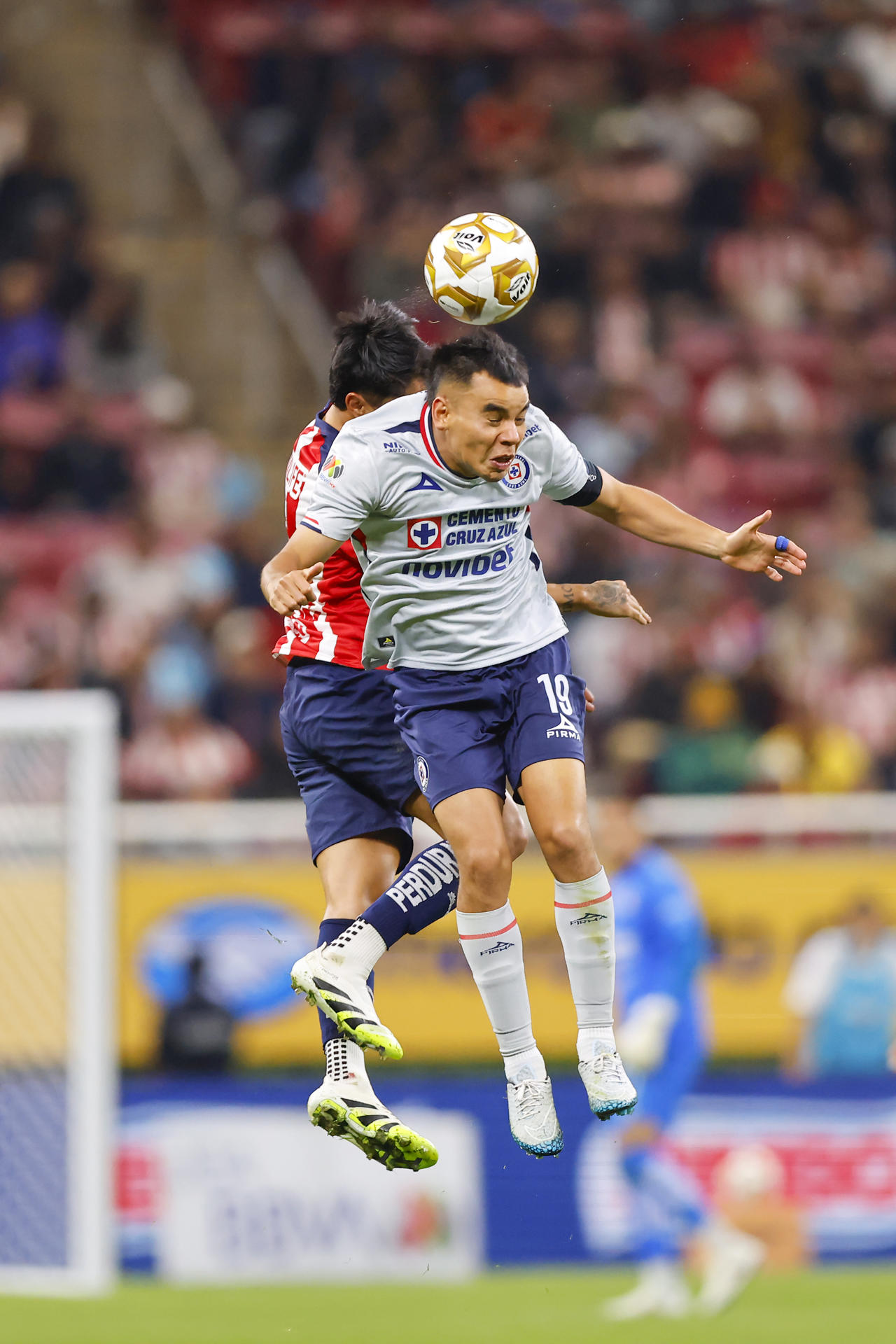 Omar Govea (i), de Guadalajara, disputa el balón con Carlos Rodríguez, de Cruz Azul, este jueves en un partido de cuartos final de la Liga MX en el Estadio Akron, en Guadalajara (México). EFE/ Francisco Guasco 