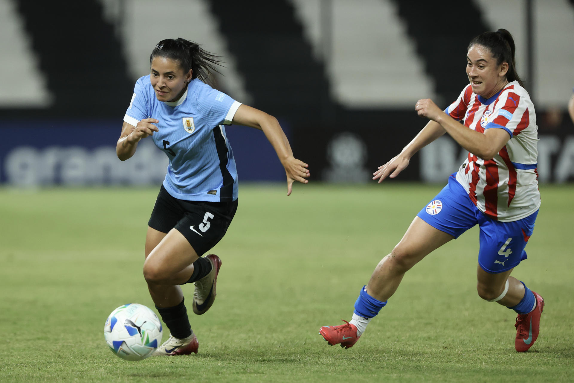 Deisy Ojeda (d), de Paraguay, disputa el balón con Ángela Gómez, de Uruguay, en un partido de la Liga de Naciones Femenina entre Paraguay y Uruguay en el estadio Tigo La Huerta, en Asunción (Paraguay). EFE/Juan Pablo Pino 