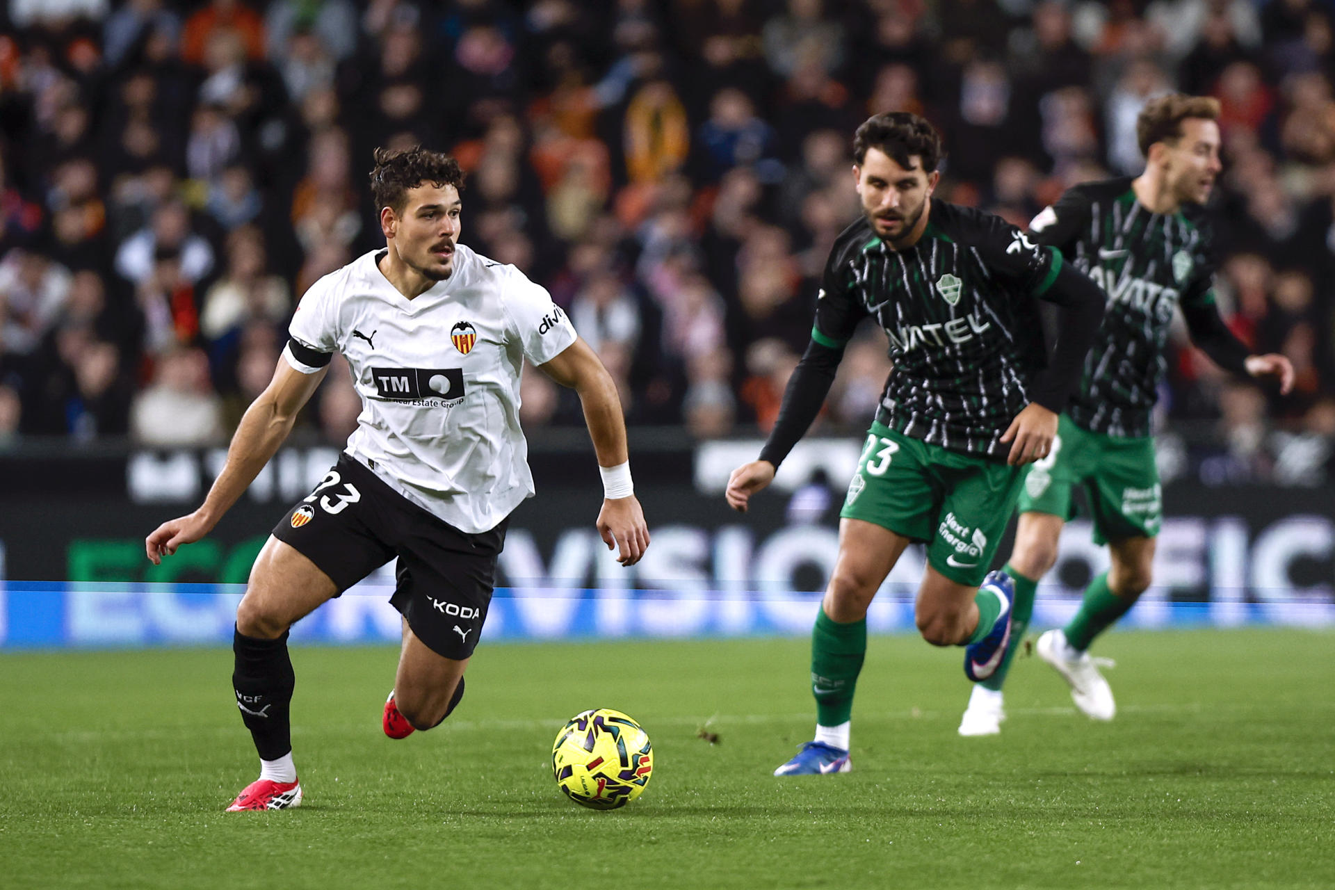 El centrocampista suizo del Valencia Filip Ugrinić (i) dirige el balón durante el partido de la jornada 19 de LaLiga EA Sports que disputan el Valencia CFy el Elche CF este sábado, en el estadio de Mestalla. EFE/ Biel Aliño 