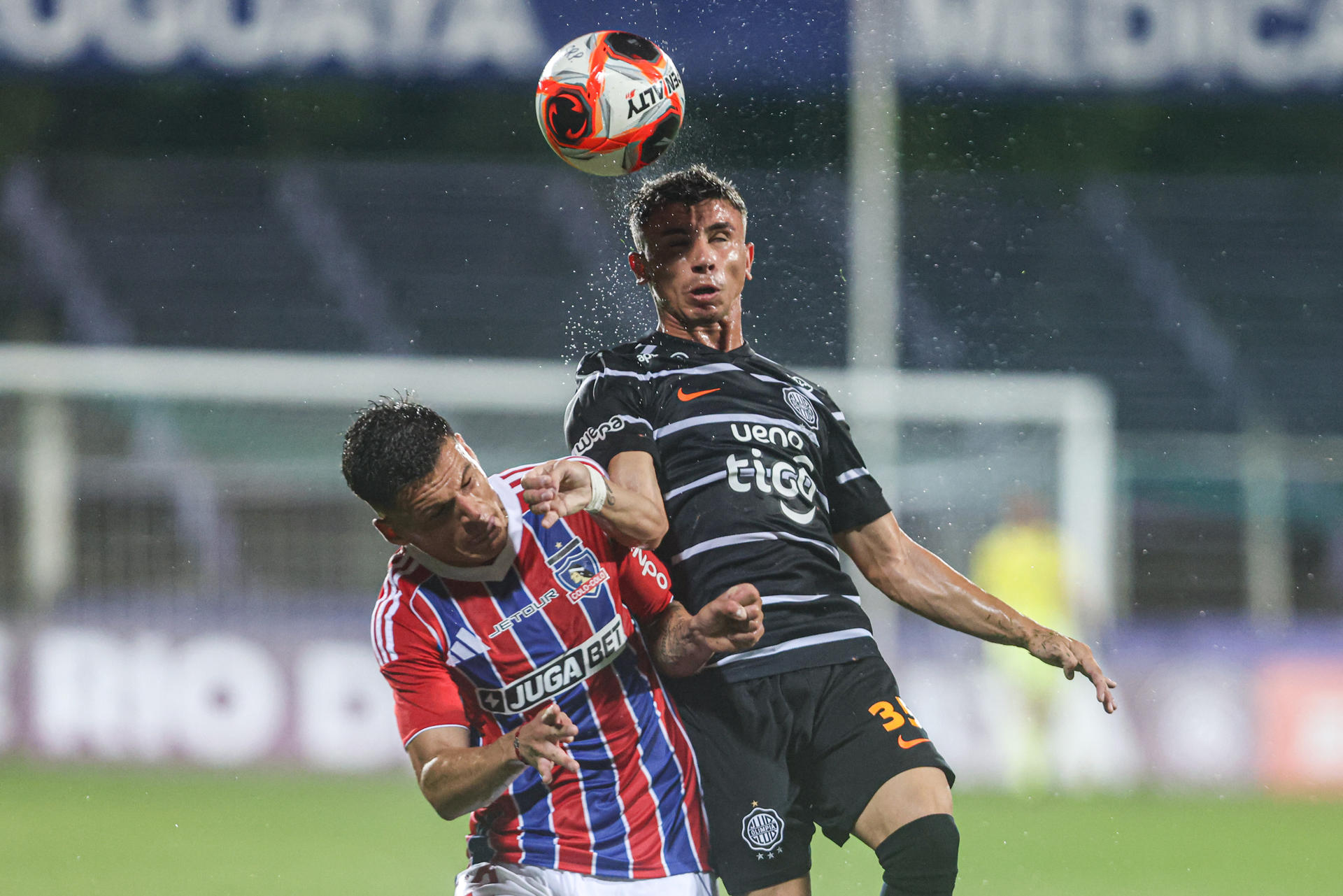 Franco Alfonso (d) de Olimpia disputa el balón con Esteban Pavez de Colo Colo este jueves durante un partido amistoso de pretemporada que el equipo chileno ganó en una tanda de penaltis en el Estadio Luis Franzini de Montevideo. EFE/ Gastón Britos 