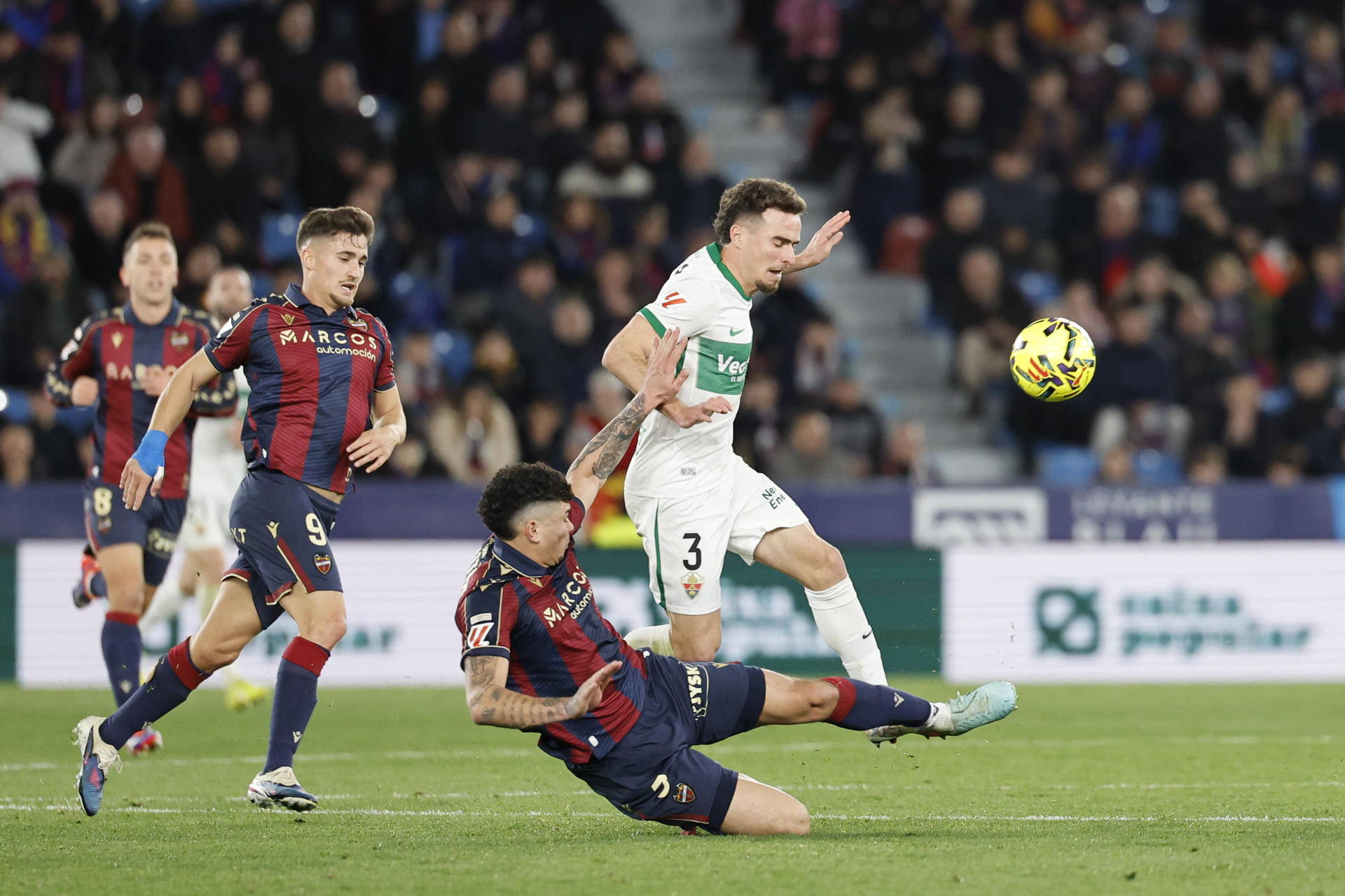 El defensa del Elche Adrià Pedrosa (d) lucha un balón durante el partido de la jornada 21 de LaLiga que Levante UD y Elche CF disputan hoy viernes en el estadio Ciutat de Valencia. EFE/Ana Escobar