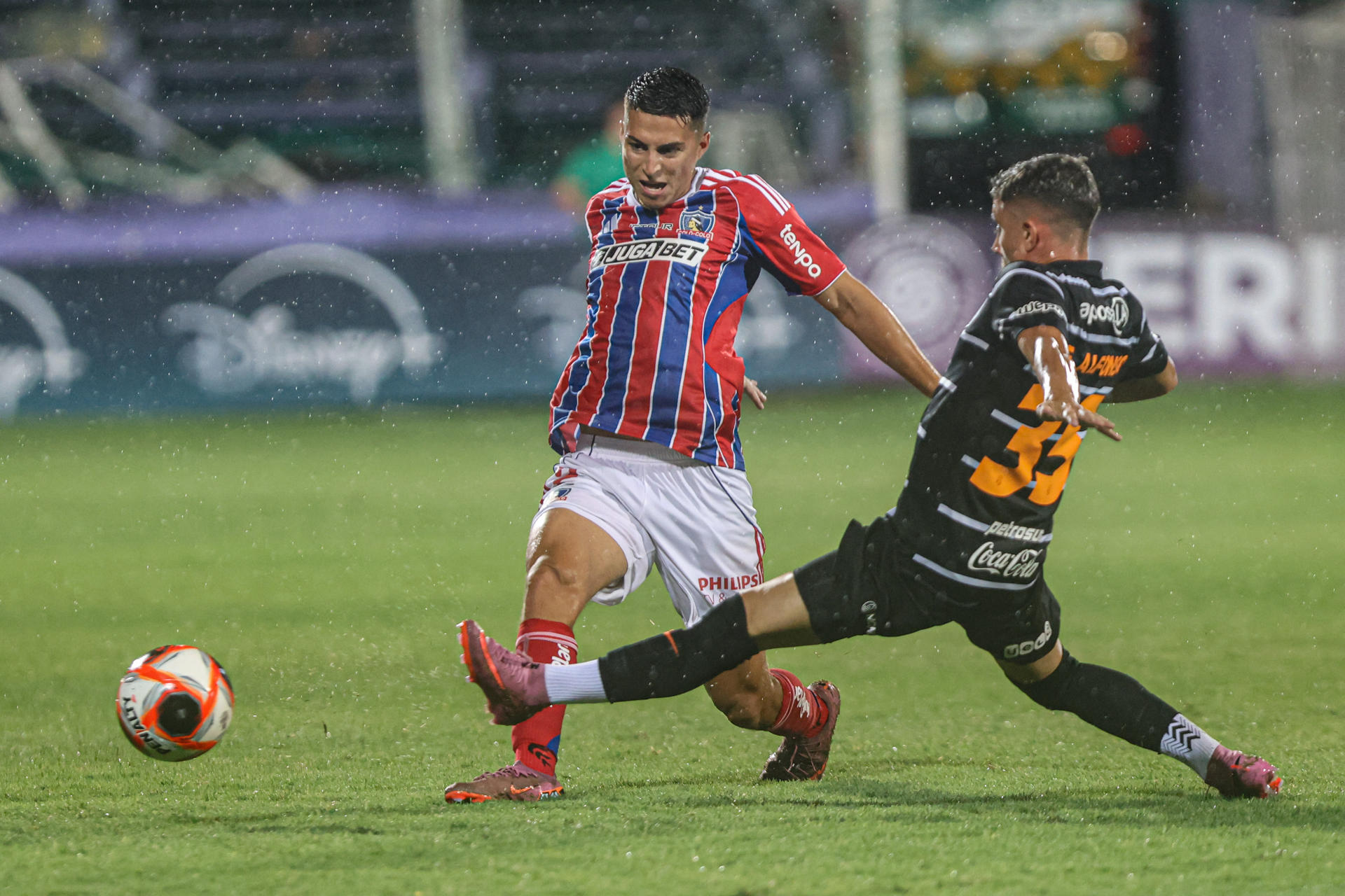 Franco Alfonso (d) de Olimpia disputa el balón con Esteban Pavez de Colo Colo este jueves durante el partido amistoso de pretemporada que el equipo chileno ganó en una tanda de penaltis en el Estadio Luis Franzini de Montevideo. EFE/ Gastón Britos 