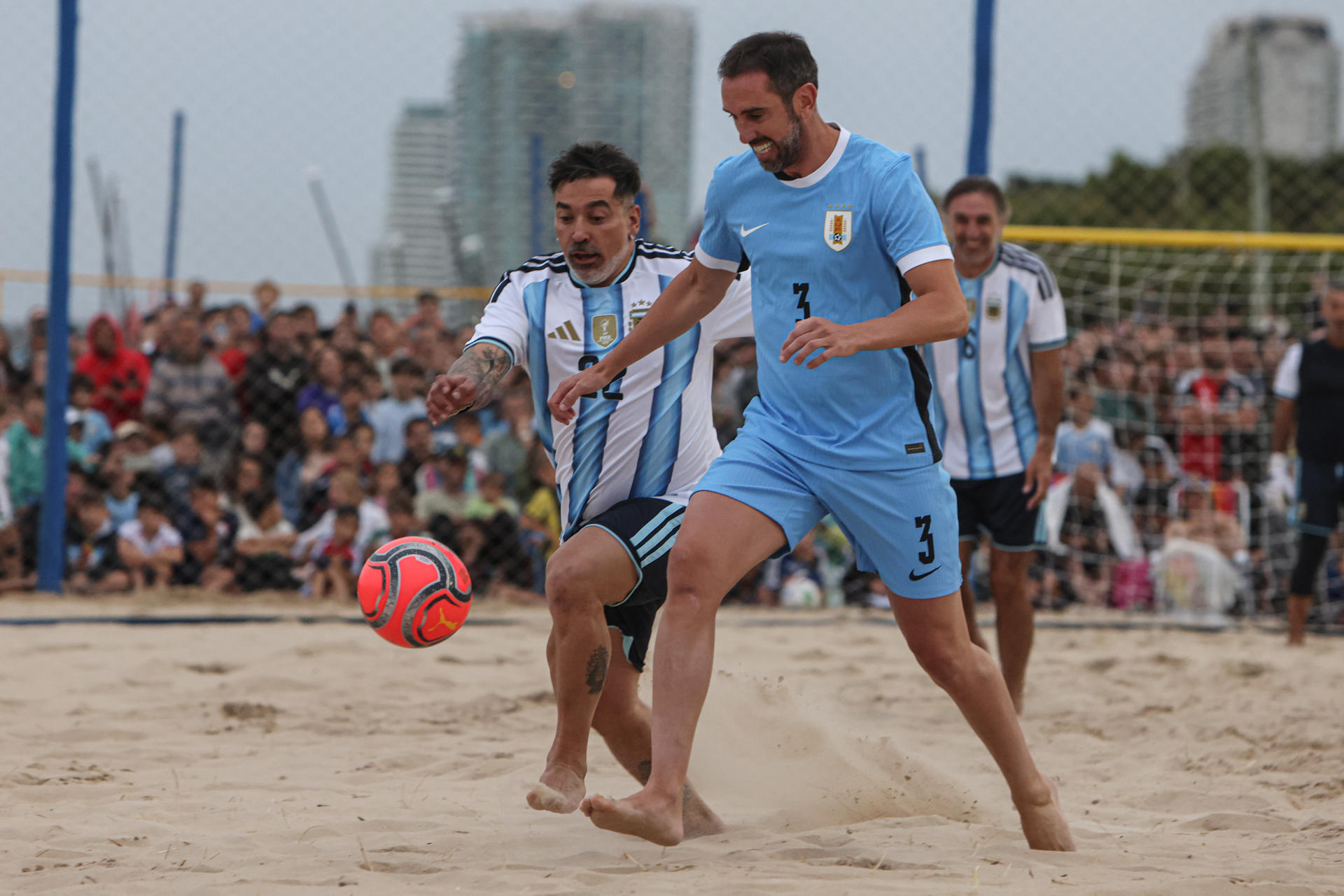 El uruguayo Diego Godin (d) disputa el balón con el argentino Ezequiel Lavezzi en un partido de exhibición de exfutbolistas jugado este viernes en Punta del Este (Uruguay). EFE/ Gastón Britos. 