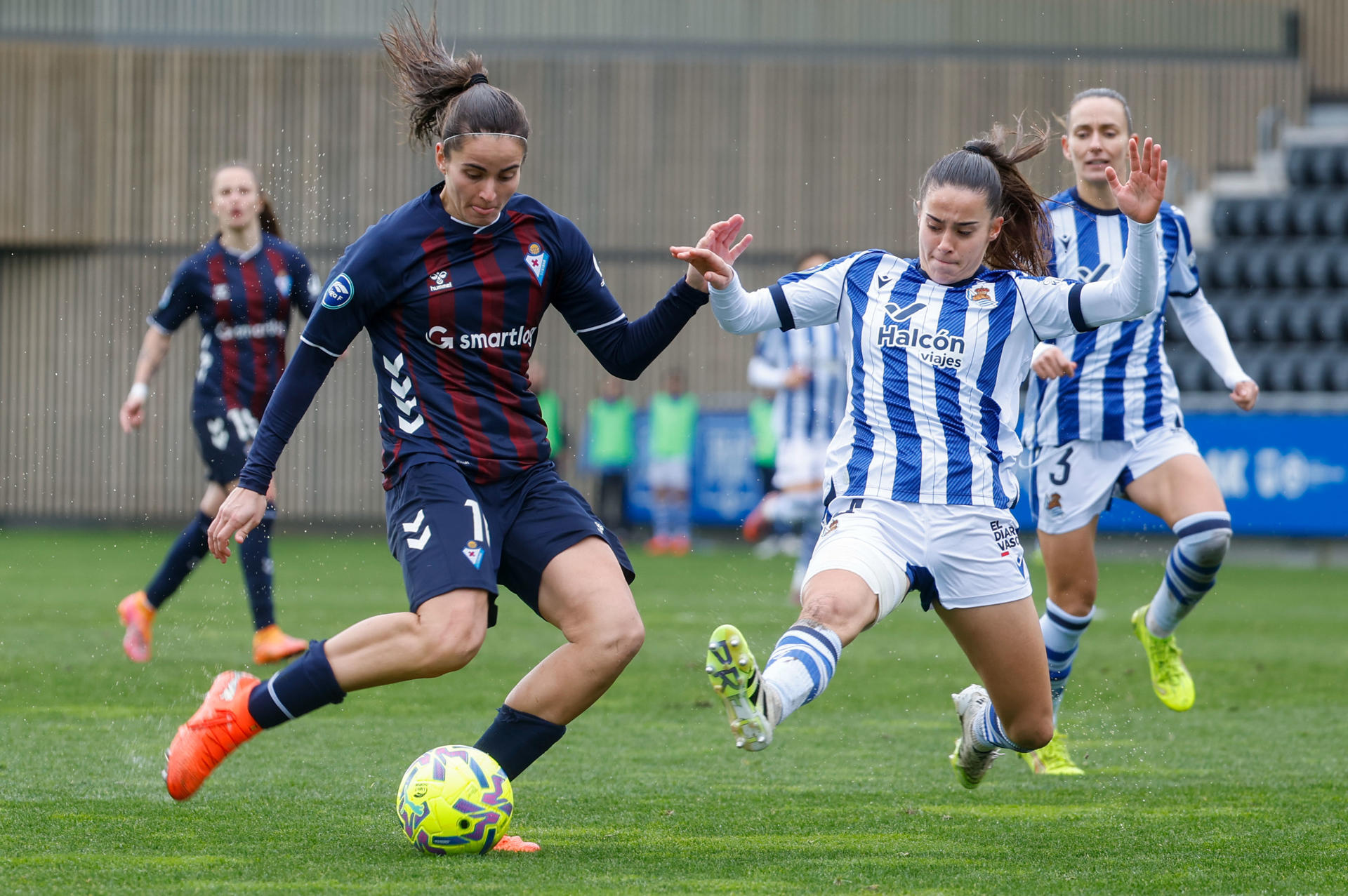 La jugadora del Eibar Carmen Álvarez (i) controla la pelota ante Naiha Aparicio (d), de la Real Sociedad, durante el partido de Liga F disputado en el estadio de Zubieta. EFE/Javier Etxezarreta 
