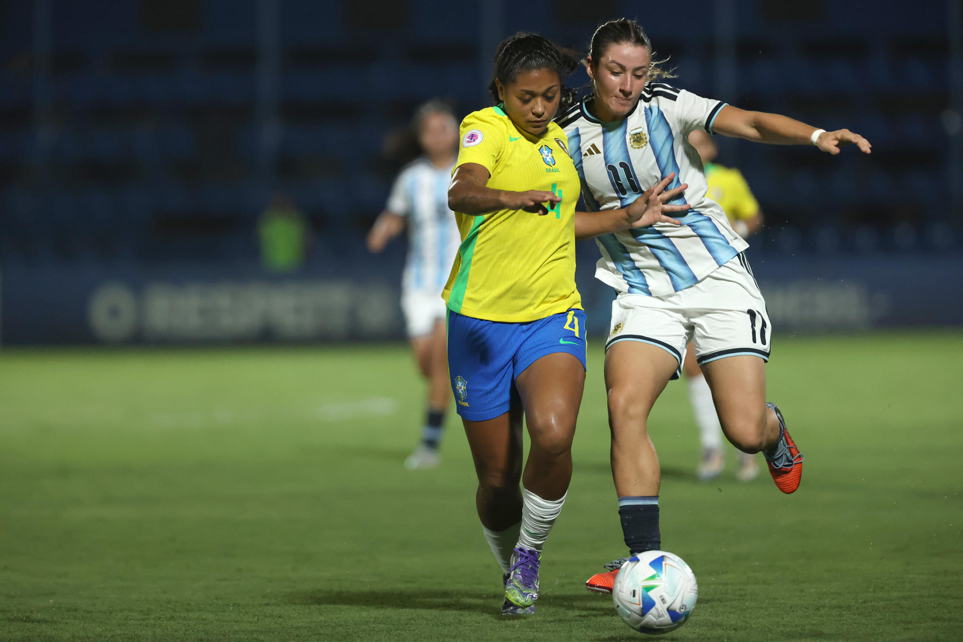Ana Souza Lopes (i), de Brasil, disputa un balón con Mercedes Diz, de Argentina, en el Sudamericano Sub-20 en el estadio Luis Alfonso Giagni en Villa Elisa (Paraguay). EFE/Juan Pablo Pino
