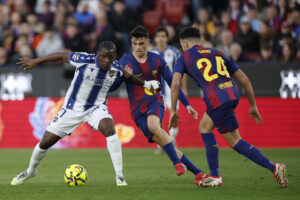 El centrocampista del FC Barcelona Pedri (c) disputa un balón con el delantero del Levante Etta Eyong (i) durante el partido de la jornada 25 de LaLiga EA Sports que FC Barcelona y el Levante UD disputaron en el Spotify Camp Nou de Barcelona. EFE/ Alberto Estevez